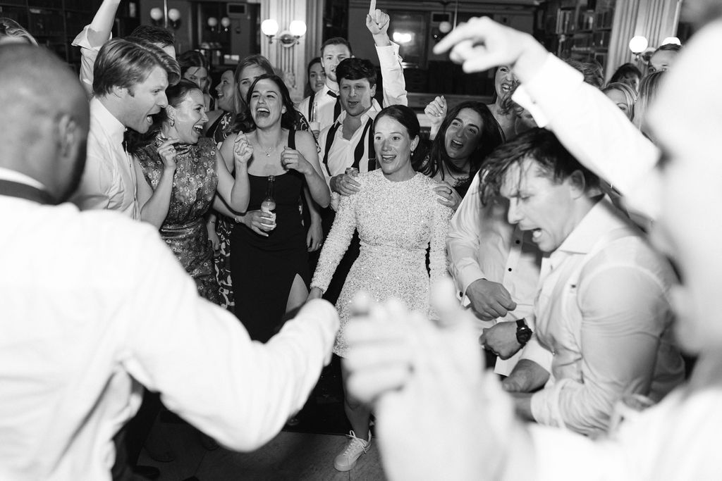 Black and white photo of enthusiastic dancers at a wedding celebration at George Peabody Library Wedding in Baltimore