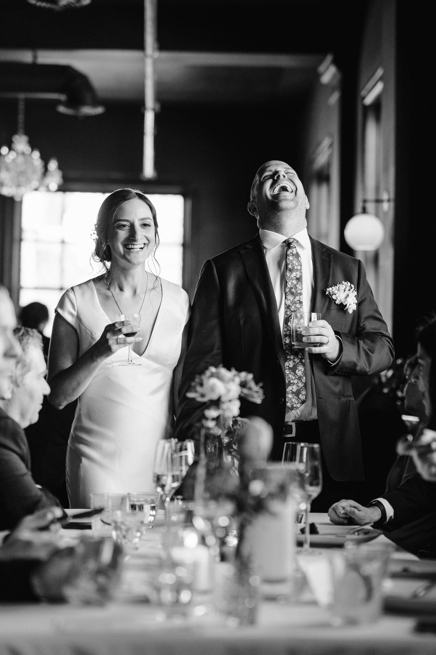 Black and white candid shots of wedding reception guests enjoying dinner conversation.