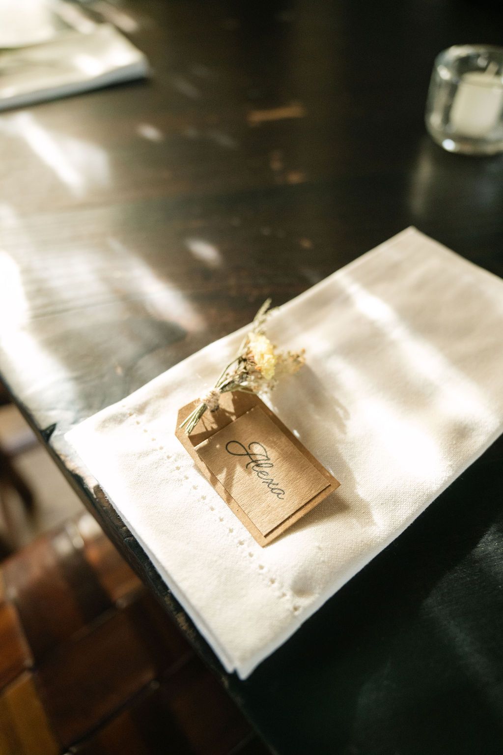 A small kraft paper favor bag with tag placed on a white napkin.