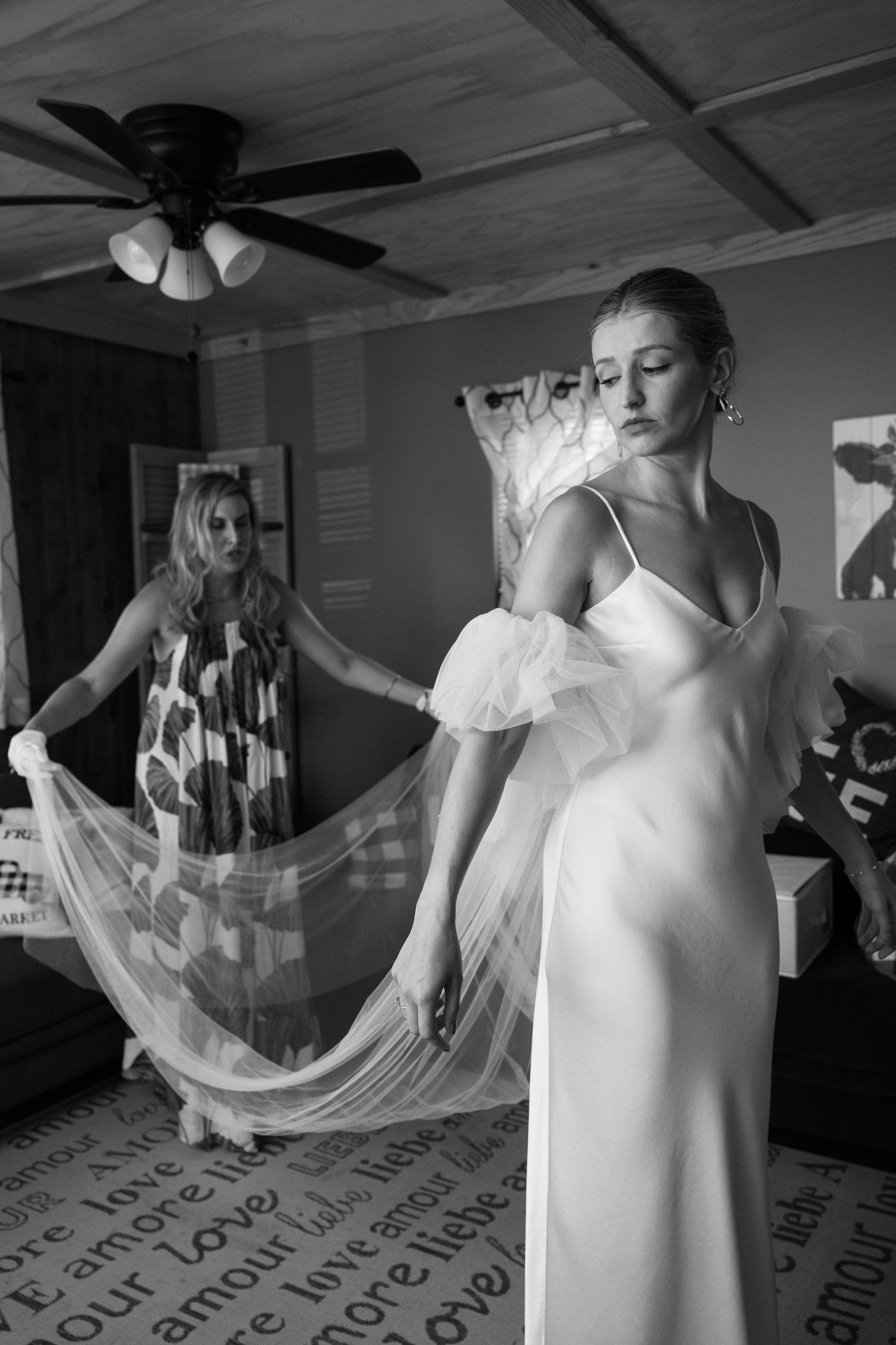 brides sister helps her into her dress