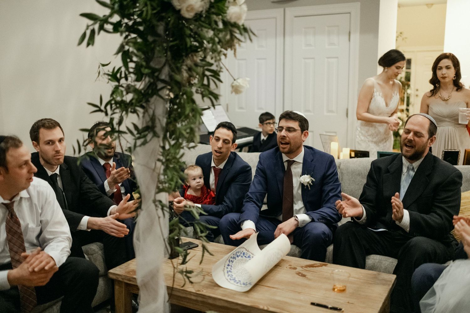 A group of well-dressed guests engage in conversation at an indoor gathering.