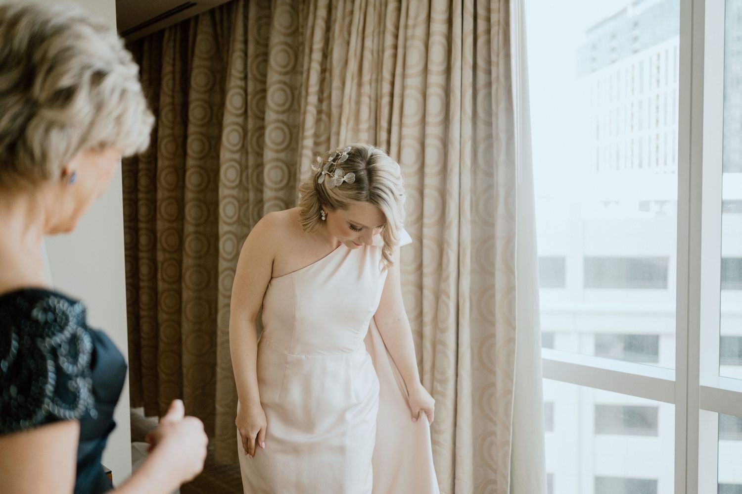 Elegant wedding preparation moment captured in a sunlit hotel room.