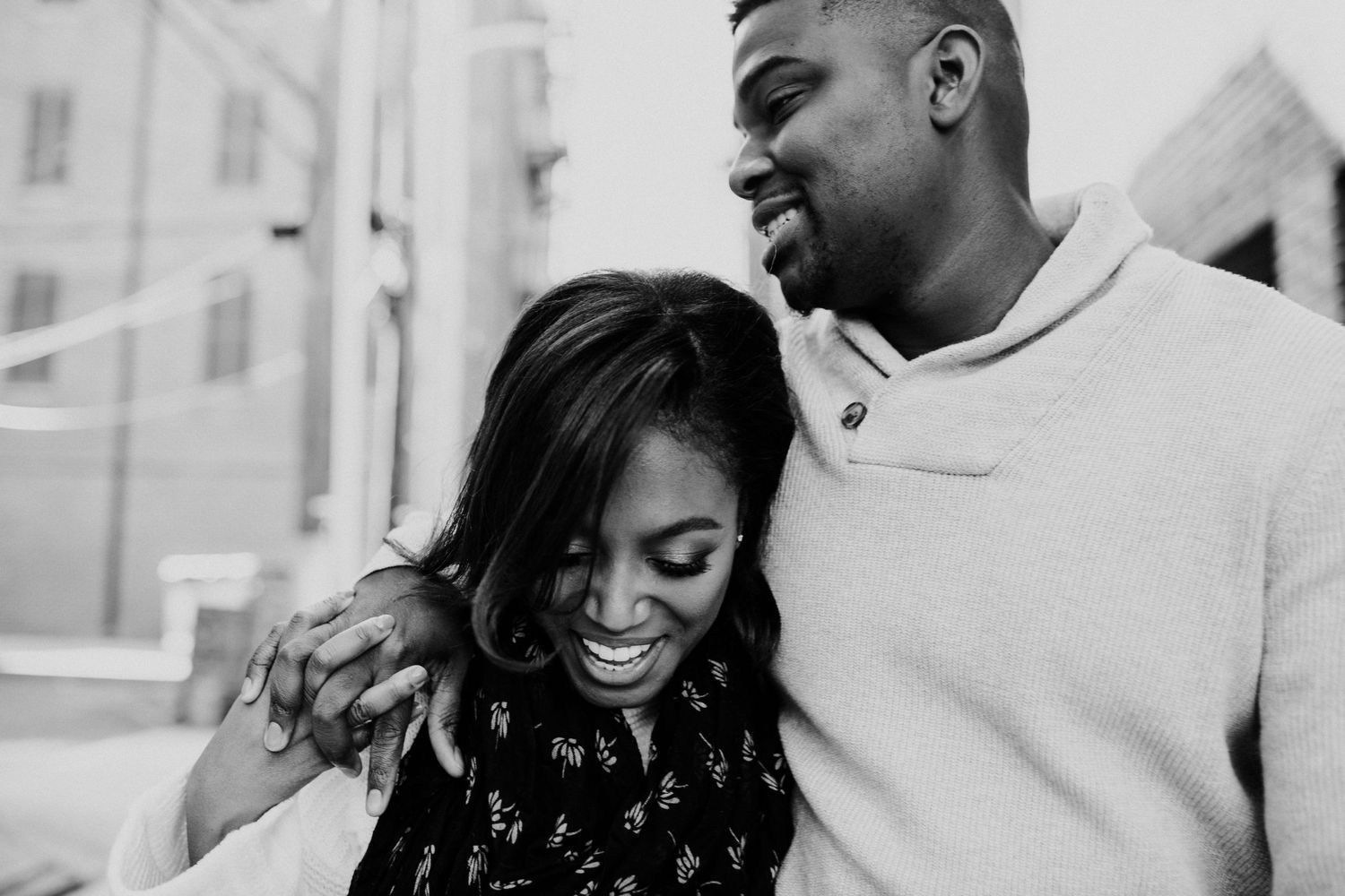A black and white portrait capturing a joyful moment between a couple.