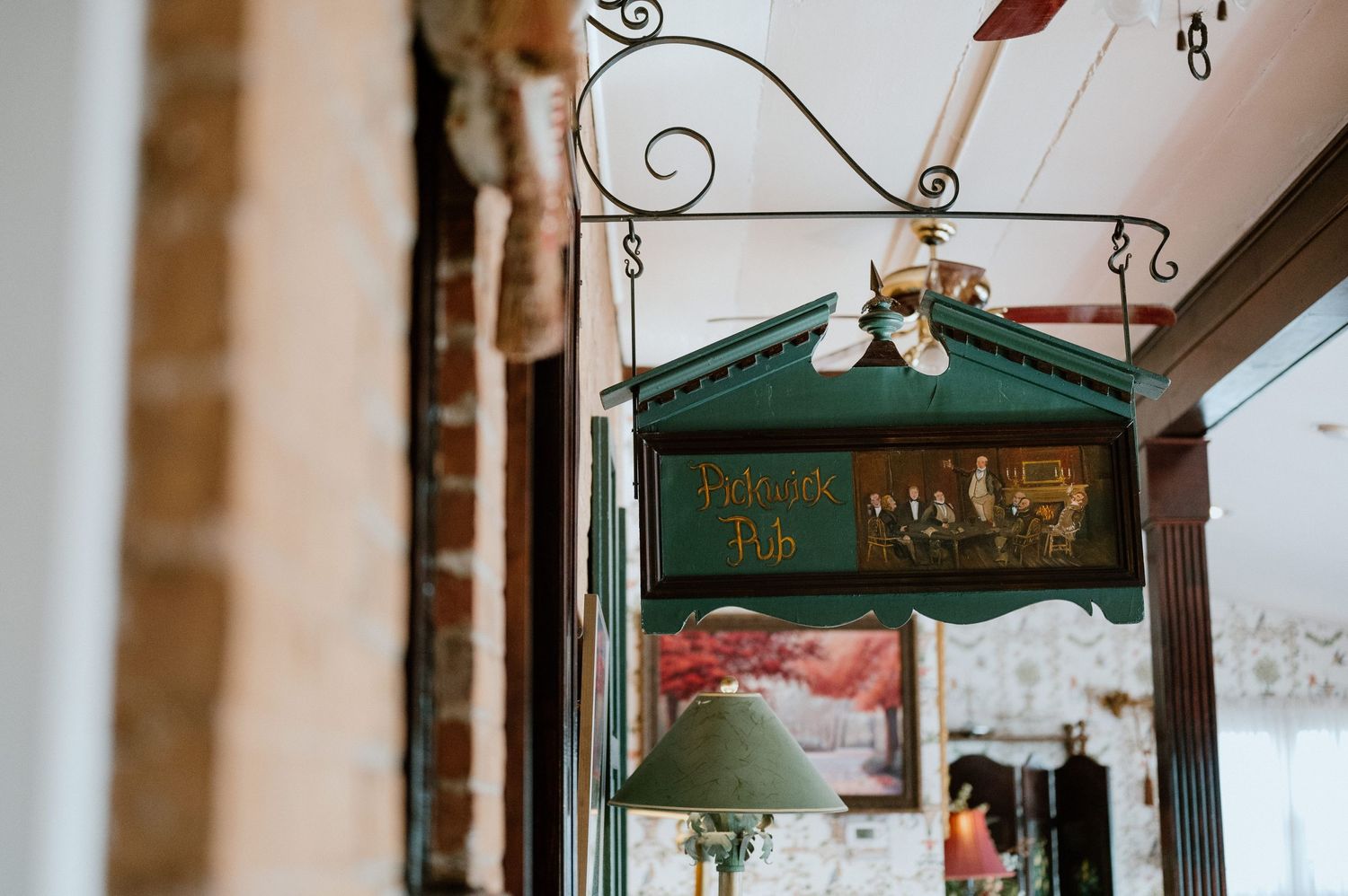 Vintage green metal mailbox hanging on exposed brick wall interior.