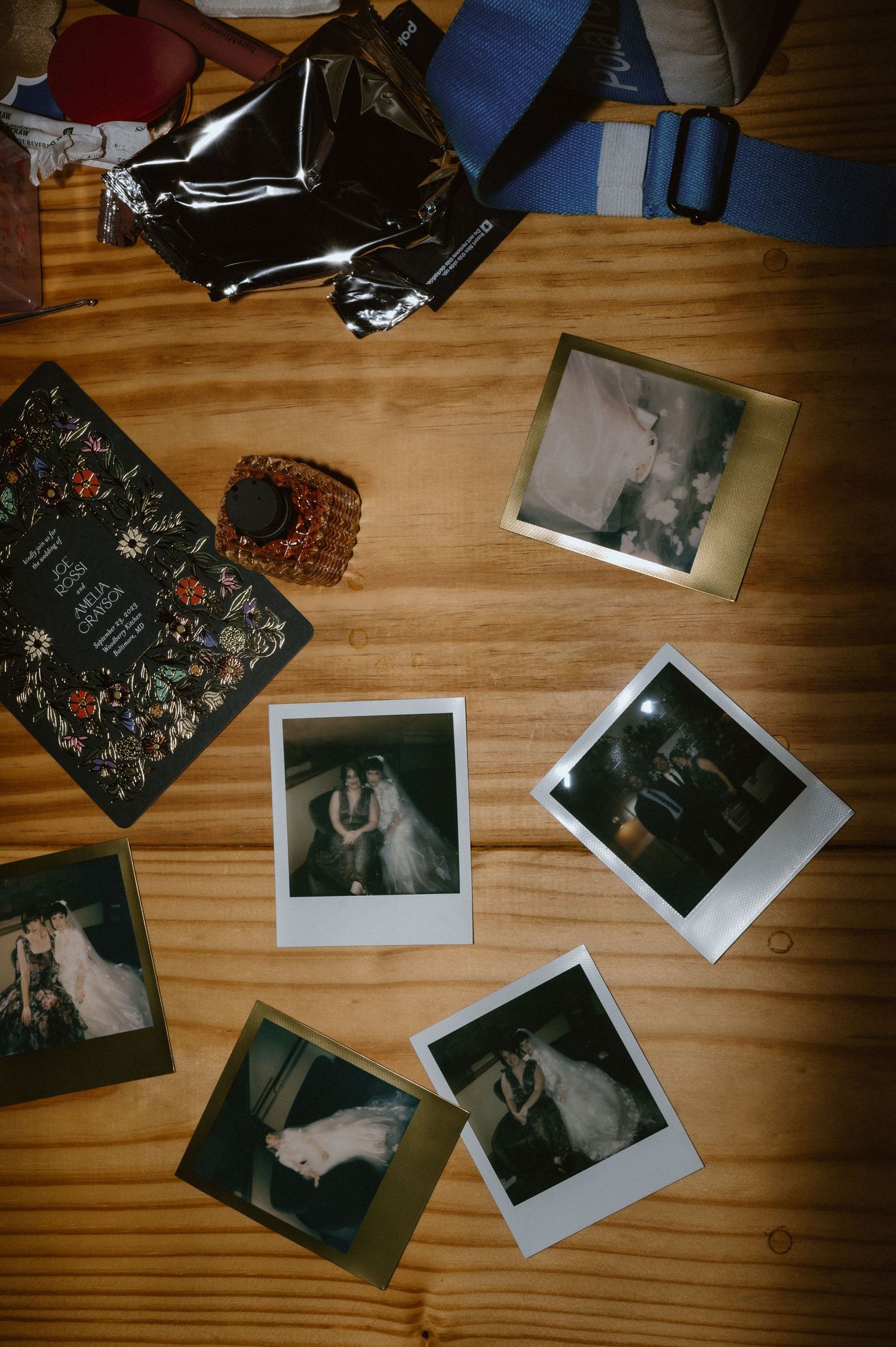Polaroid photos and personal items scattered on a wooden surface showing candid wedding moments.