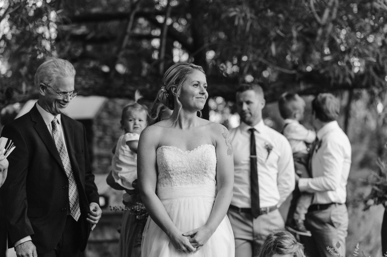 Black and white photo of a wedding ceremony with attendees gathered outdoors.