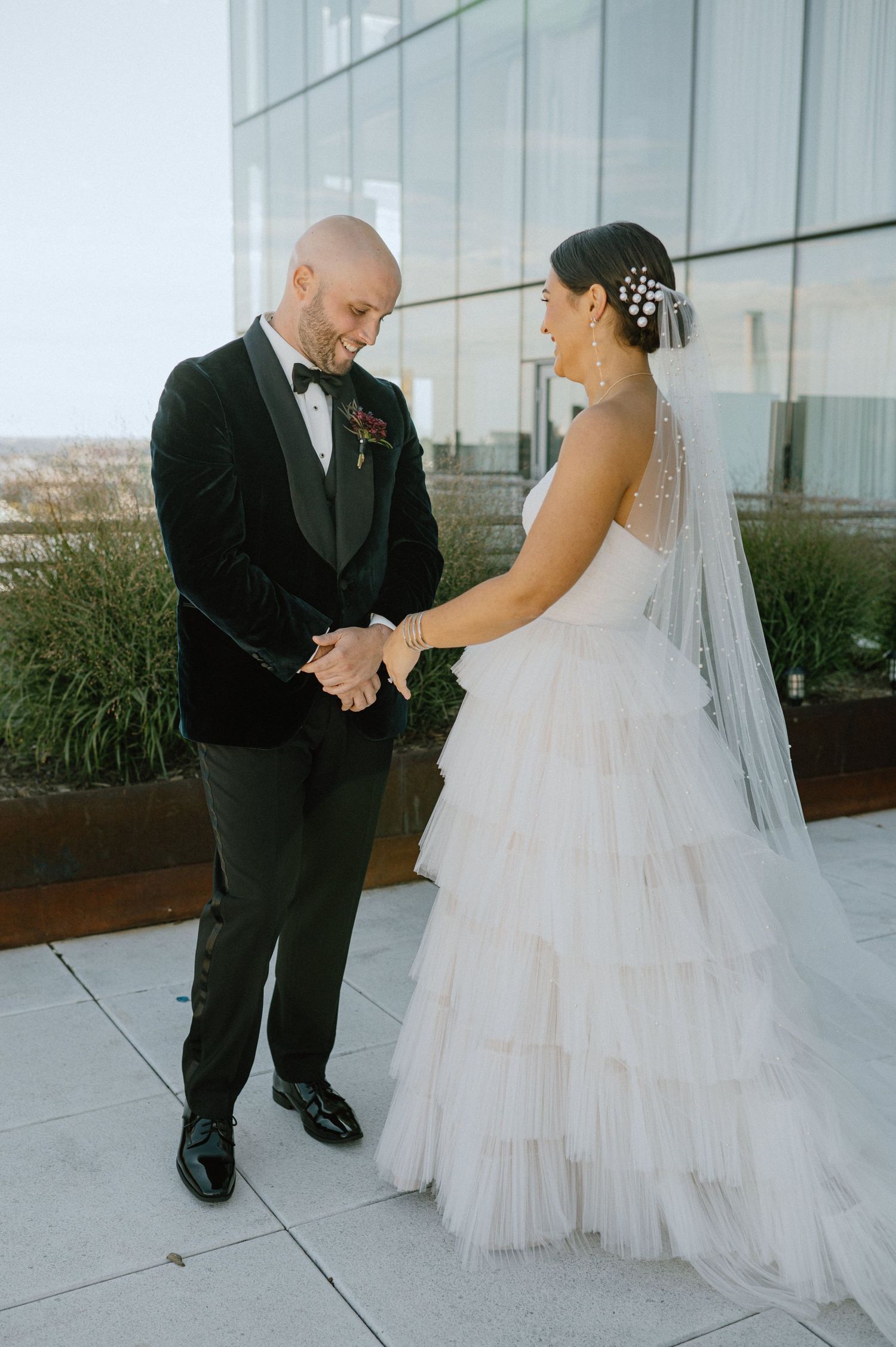 A couple shares their first look moment on a modern rooftop terrace.