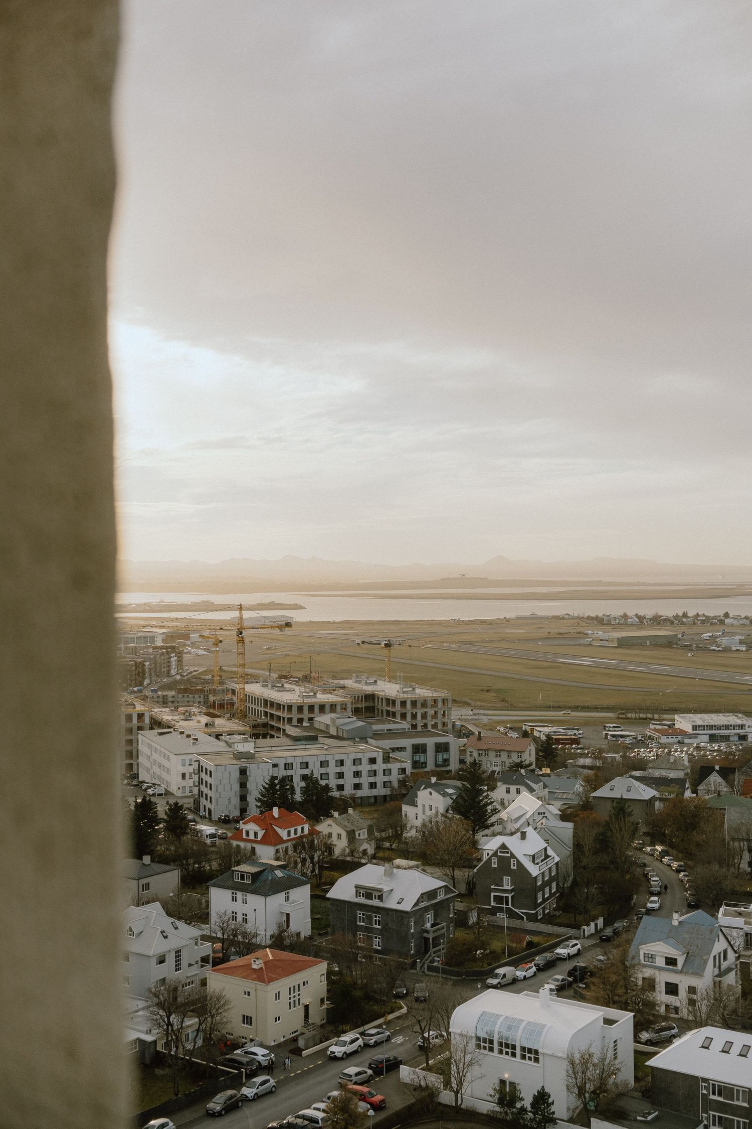 Elevated winter view of Reykjavik's suburban area with houses scattered near the coast.