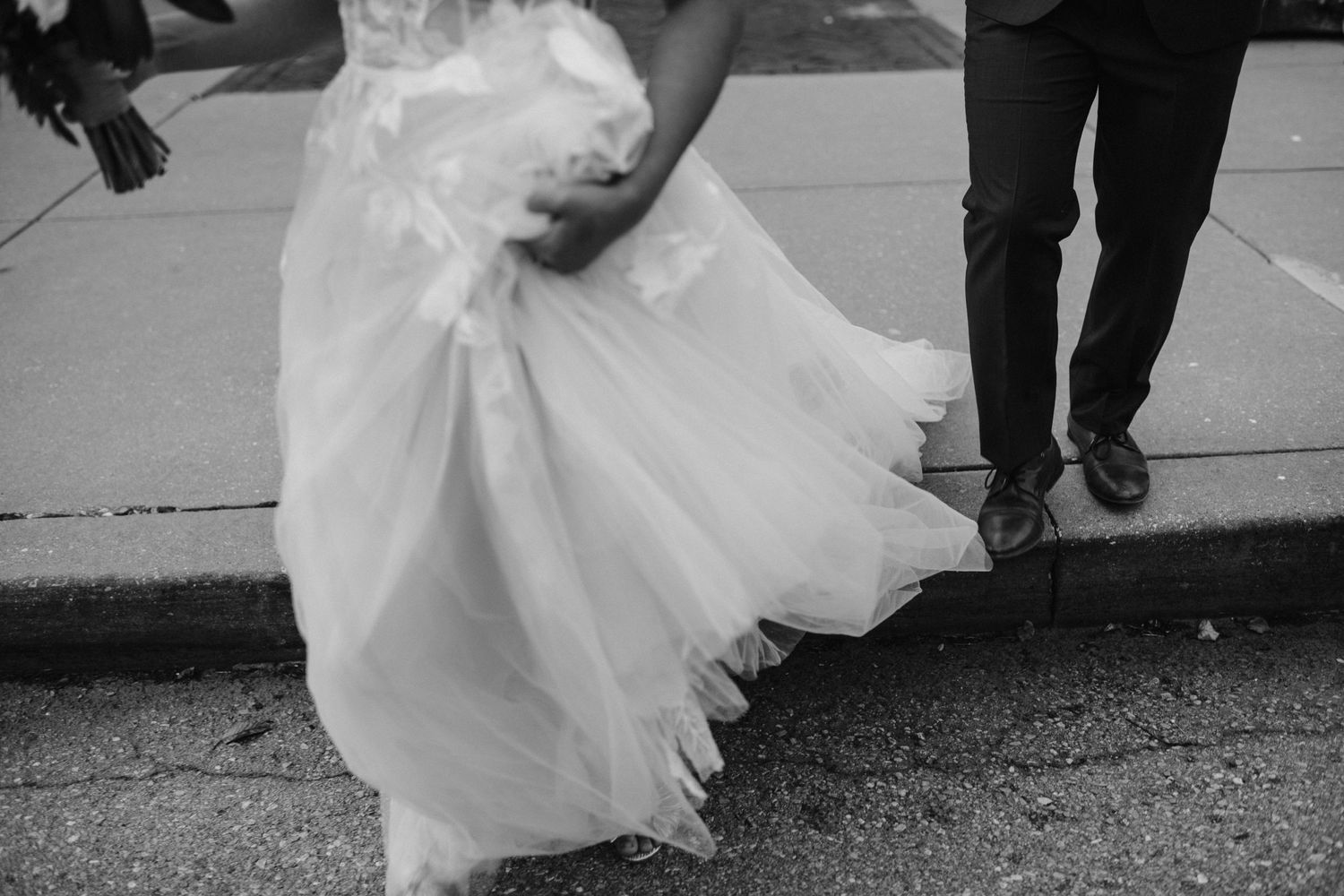 bride and groom walk together closeup of wedding dress layers