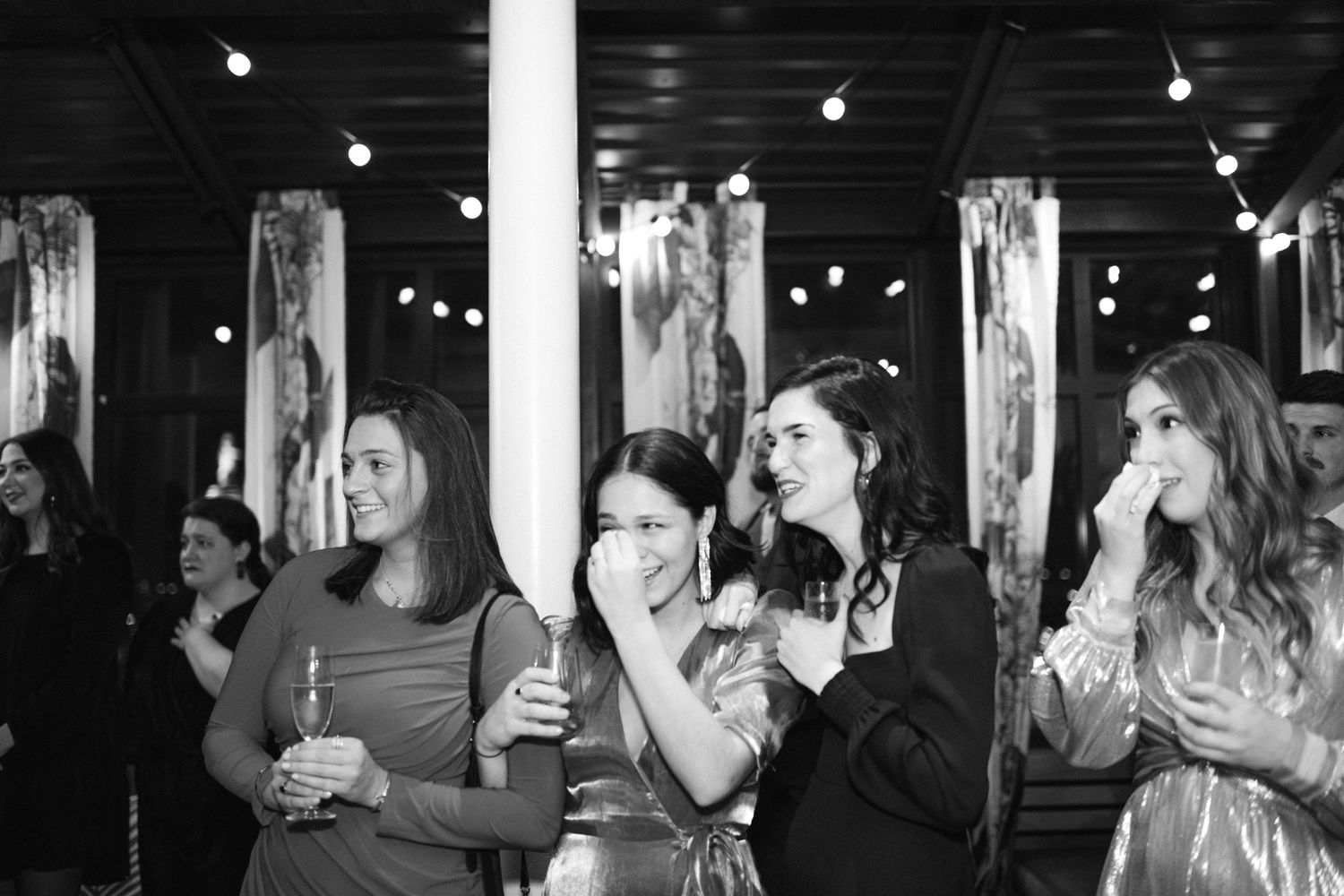 Black and white photo of guests enjoying an indoor celebration.
