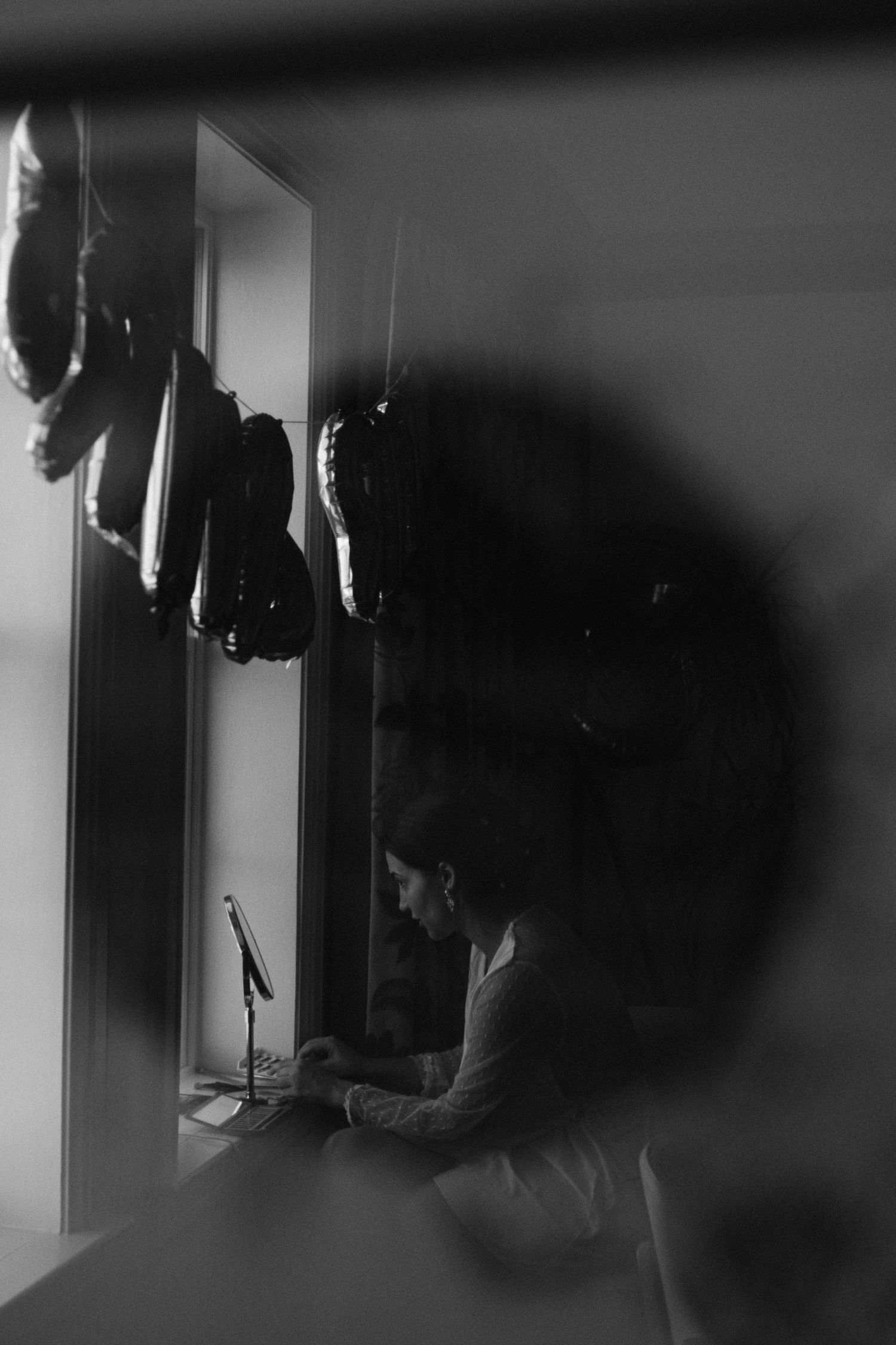 Artistic black and white silhouette portrait in moody window lighting.
