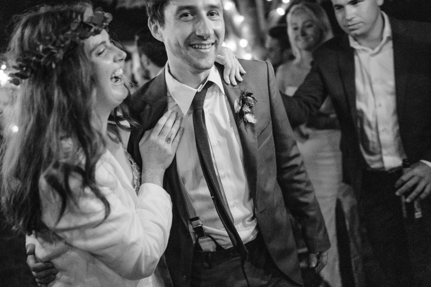 A candid black and white shot of a couple dancing at their wedding reception.