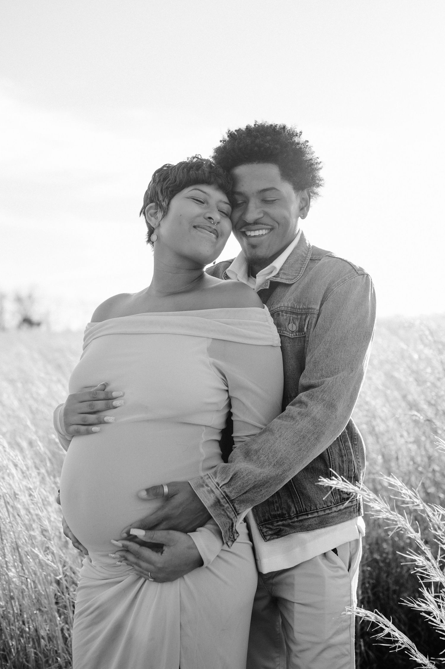 pregnant couple hugs in field at maternity photoshoot in maryland