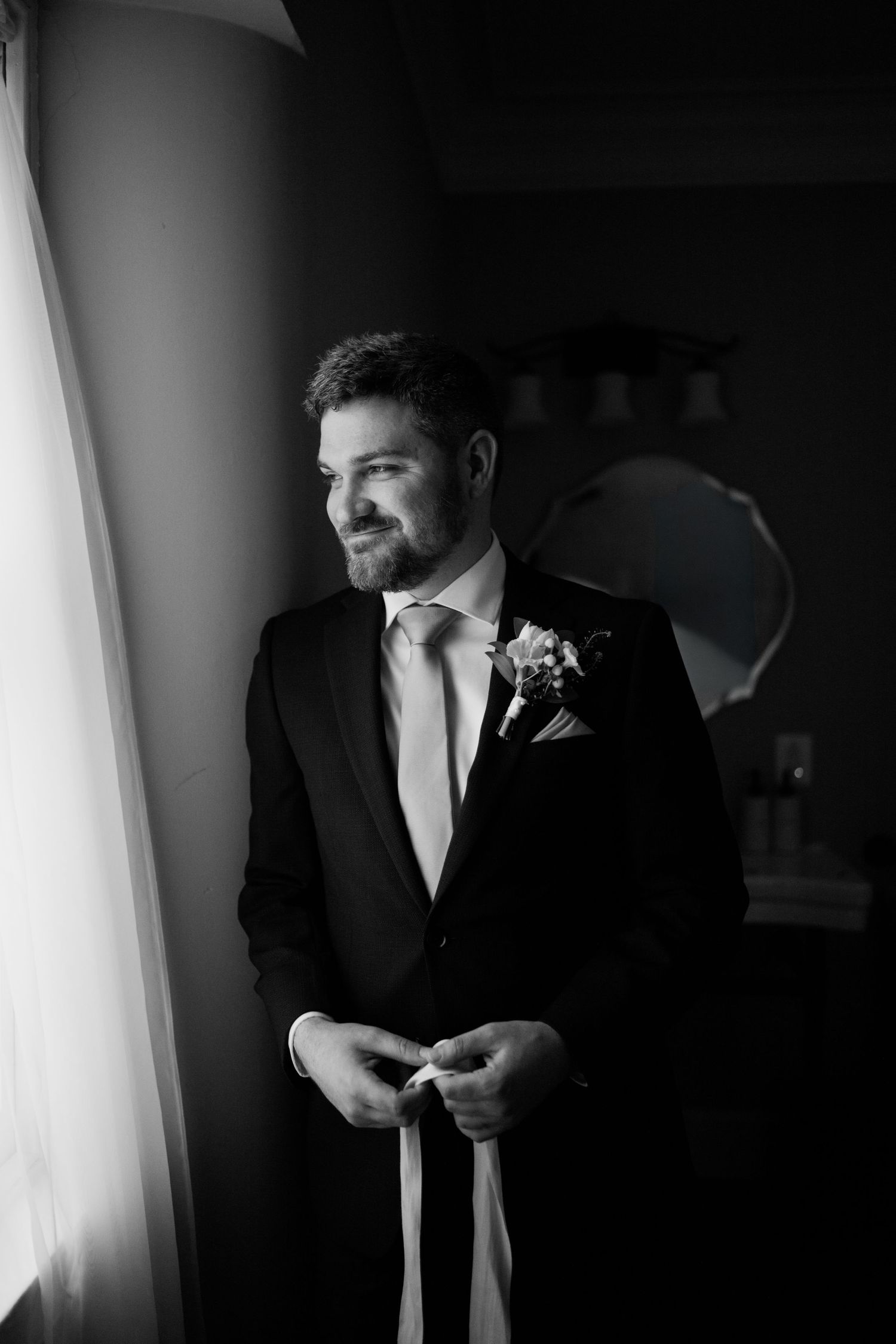 groom standing by window at mt. Ida inn ellicott city maryland wedding venue