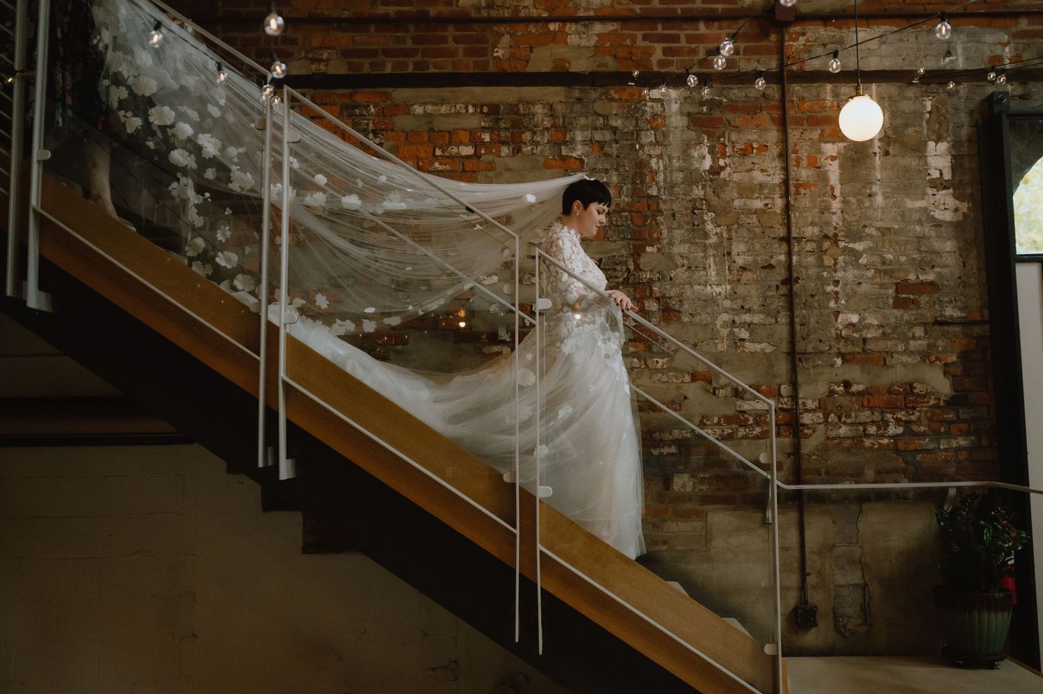 bride enters ceremony down staircase at woodberry kitchen