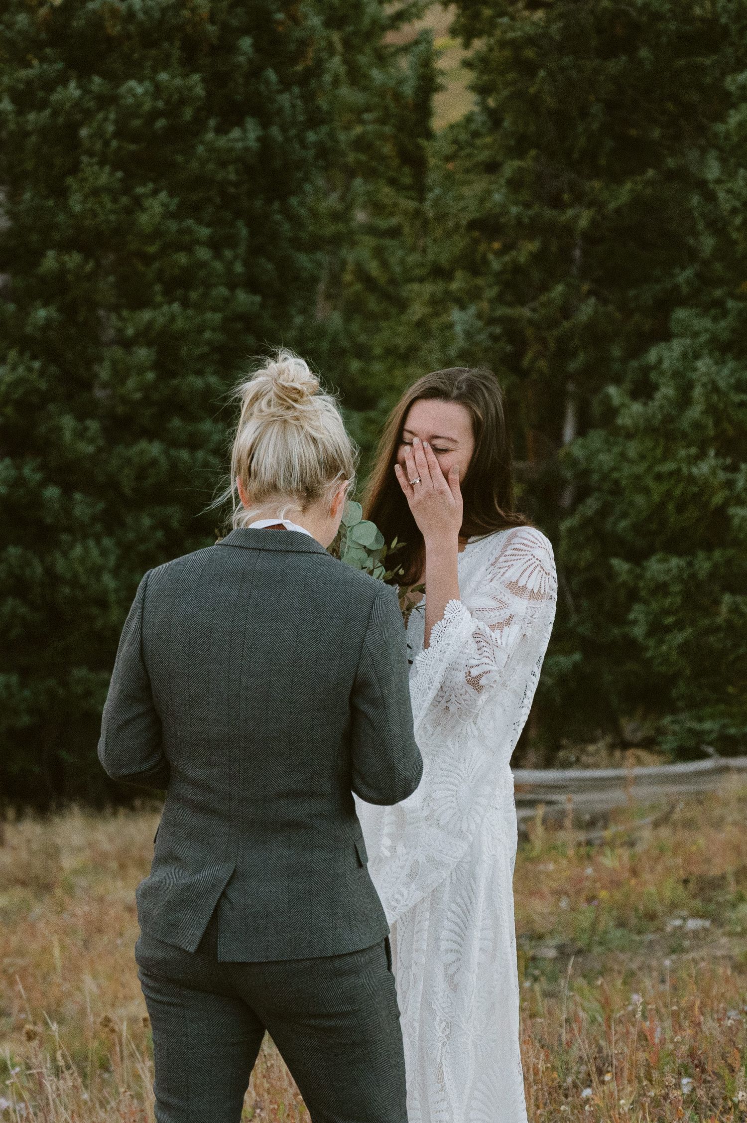 Emotional moment shared between two people during outdoor mountain ceremony.