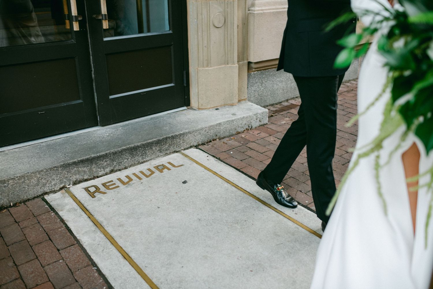 A striped wedding dress and black suit visible near a doorstep with 'Revival' text.