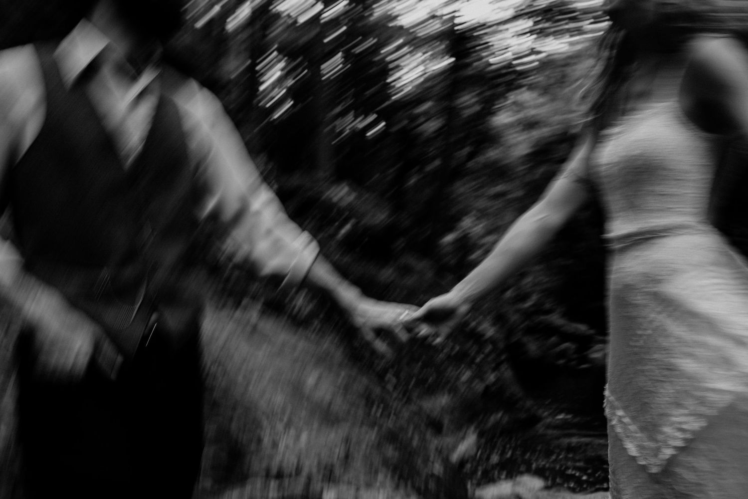 Motion-blurred black and white photograph depicting movement in a forest setting.