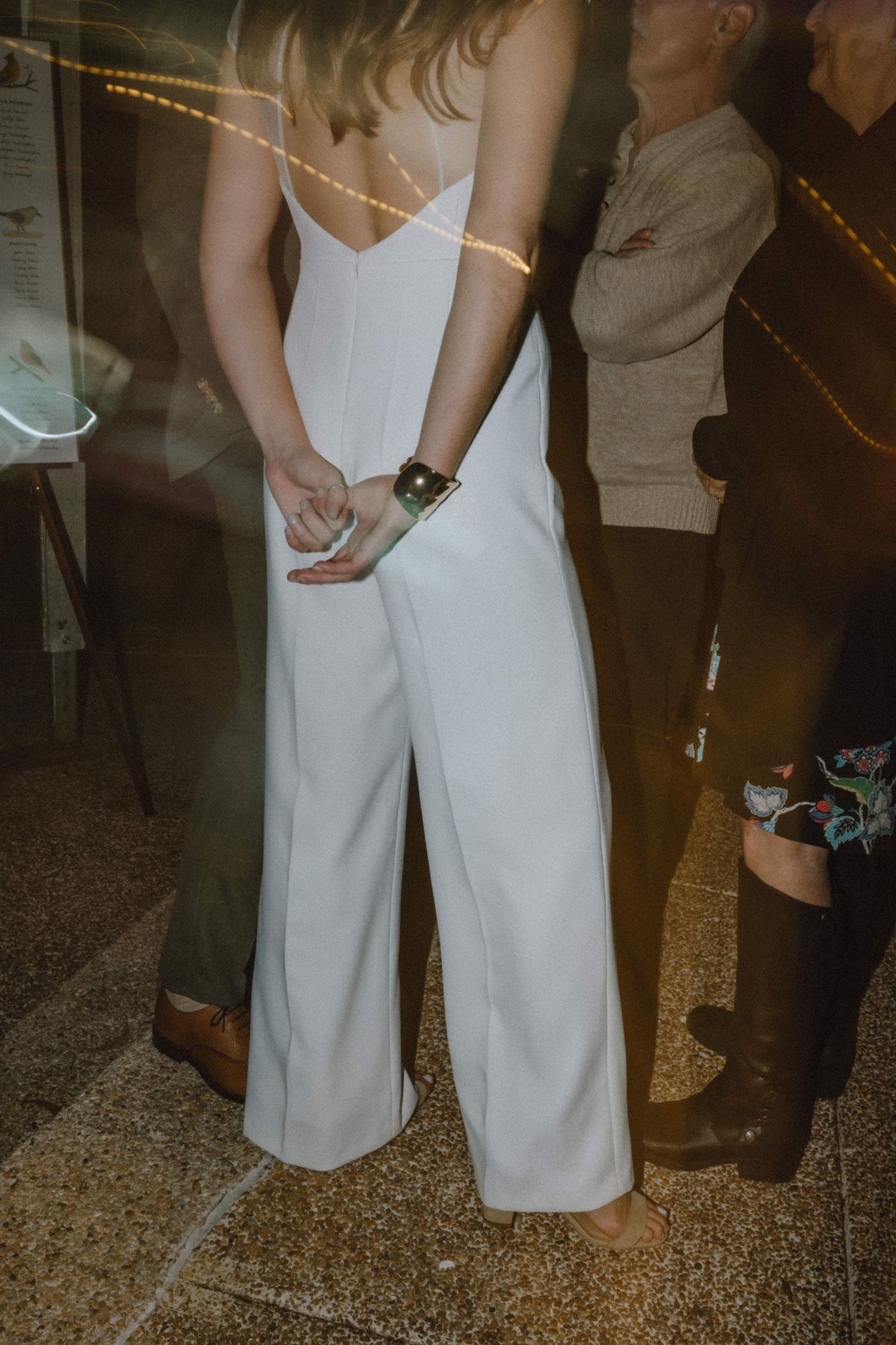 Close-up of white jumpsuit wedding attire with delicate spaghetti straps.