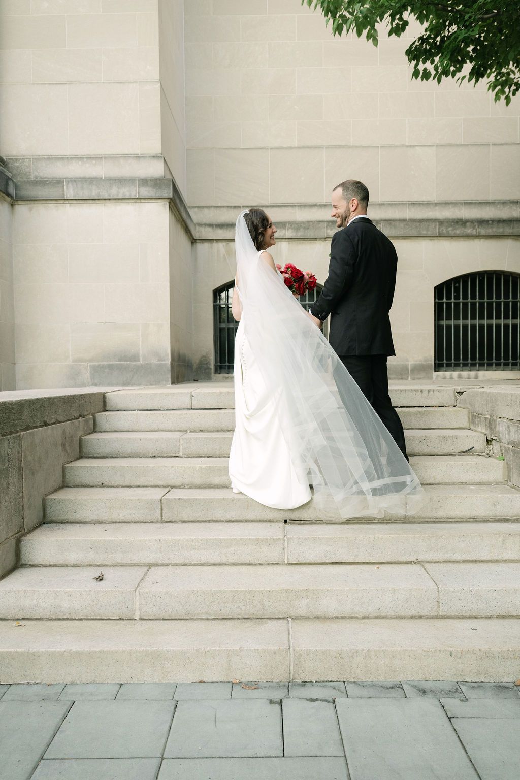 A series of four wedding photos showing a couple descending stone steps in formal attire with a white dress trailing behind.