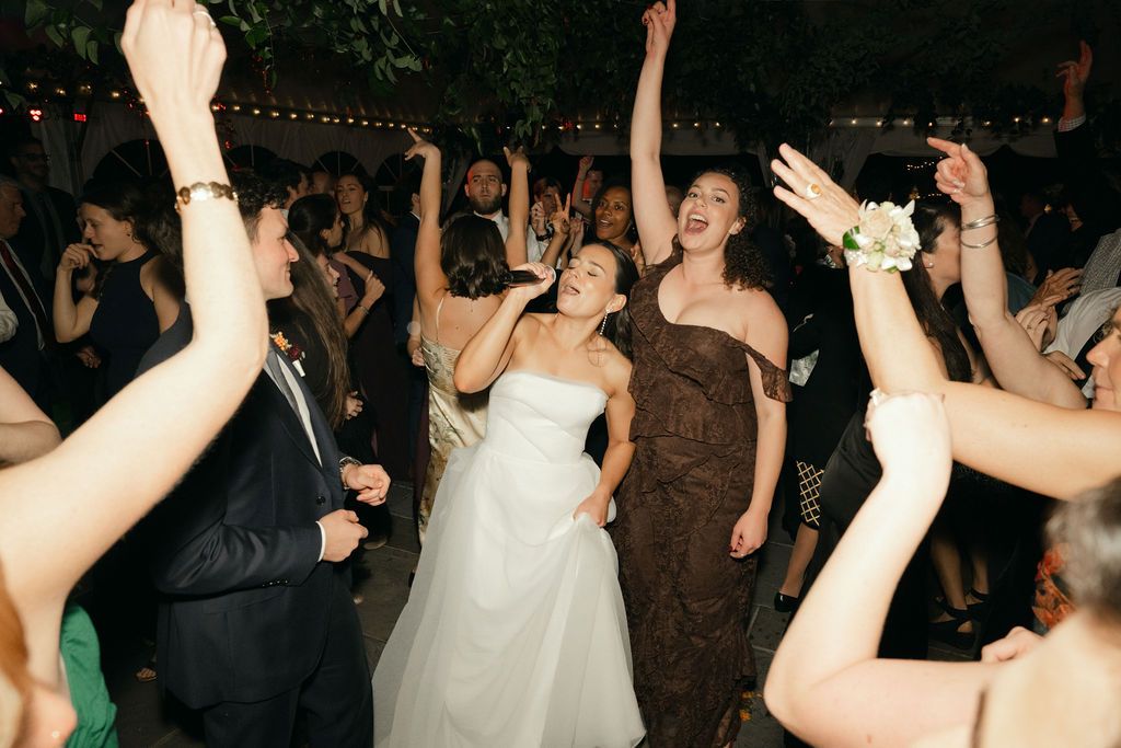 Wedding guests dance with raised arms during a festive reception celebration at Strong Mansion on Sugarloaf Mountain