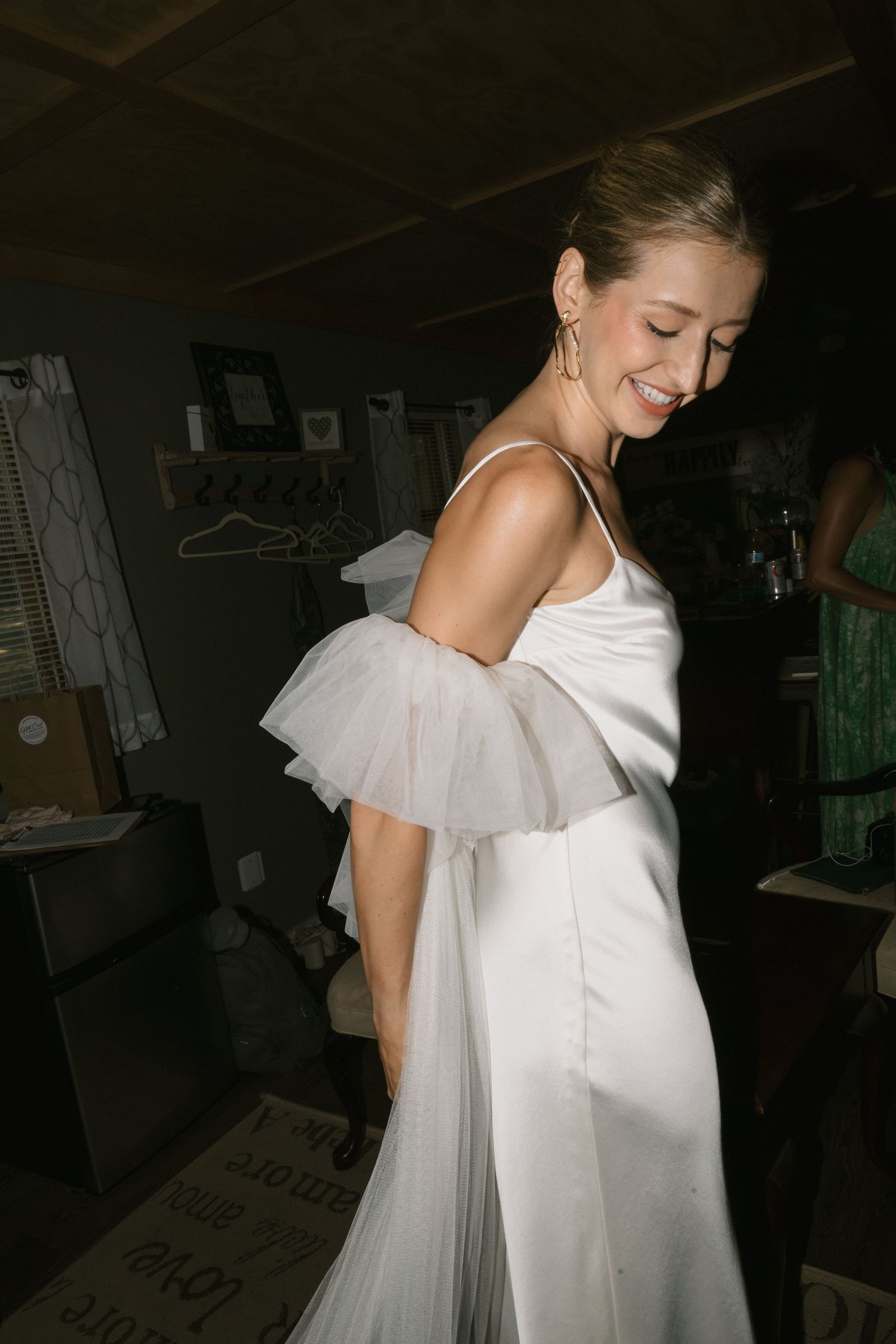 Wedding dress with delicate tulle details photographed in an intimate indoor setting.
