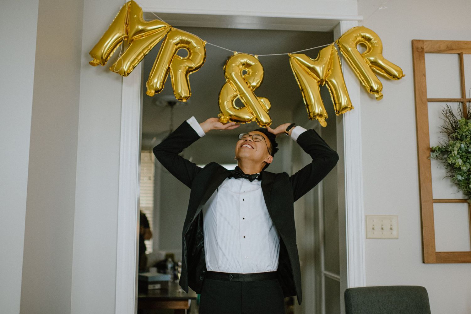 Gold balloon letters decorate an indoor wedding venue space.