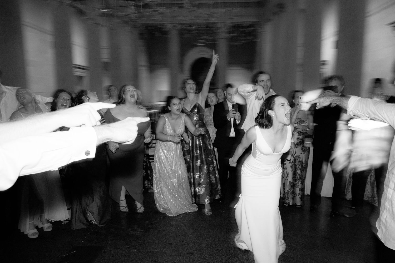 Blurred motion shots of wedding guests dancing at a dimly lit reception.