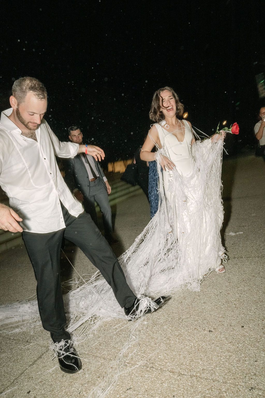 A sequence of dance moves showing a person in white spinning and twirling on a concrete surface at night.