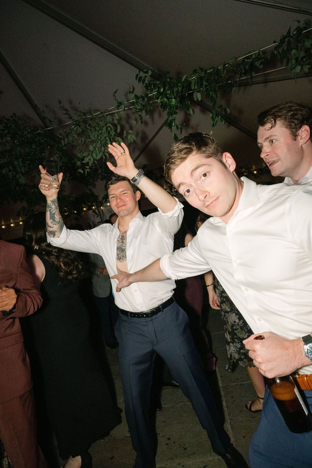 Guests in white shirts and formal wear dance energetically at a wedding reception at Strong Mansion on Sugarloaf Mountain