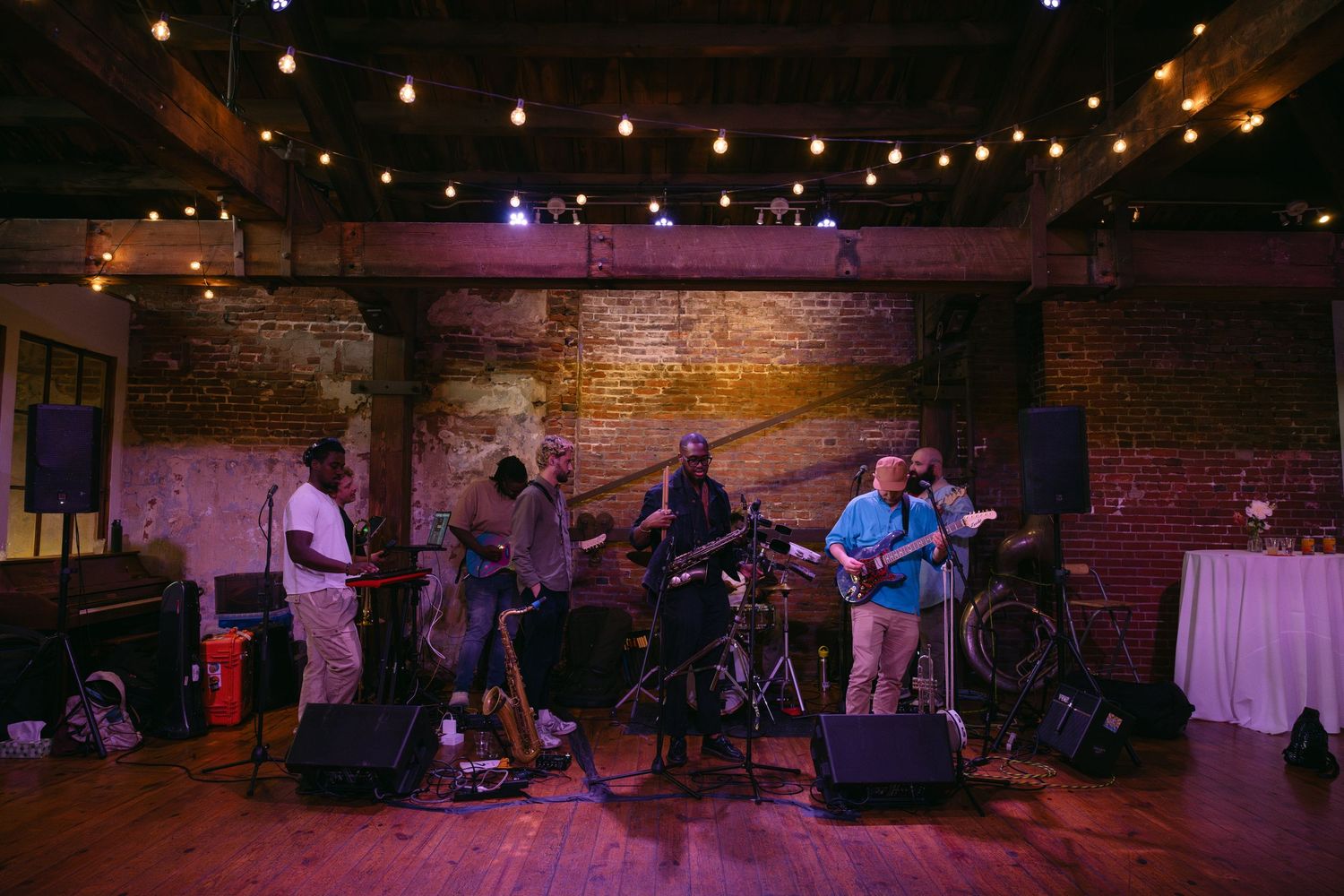 Dark event venue with stage lights and music equipment set up for live performance.