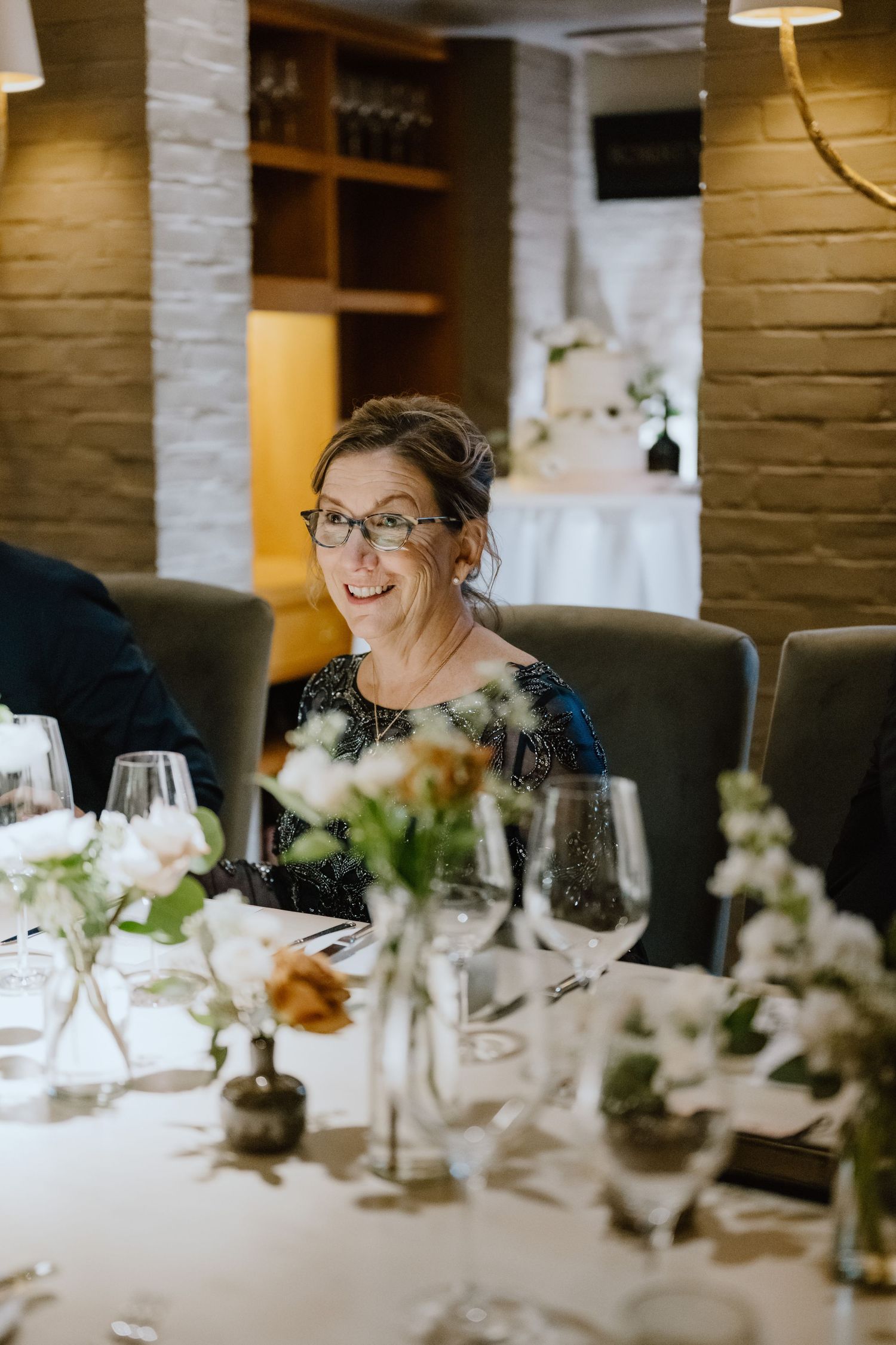 A joyful moment captured during a wedding reception dinner with elegant table settings.