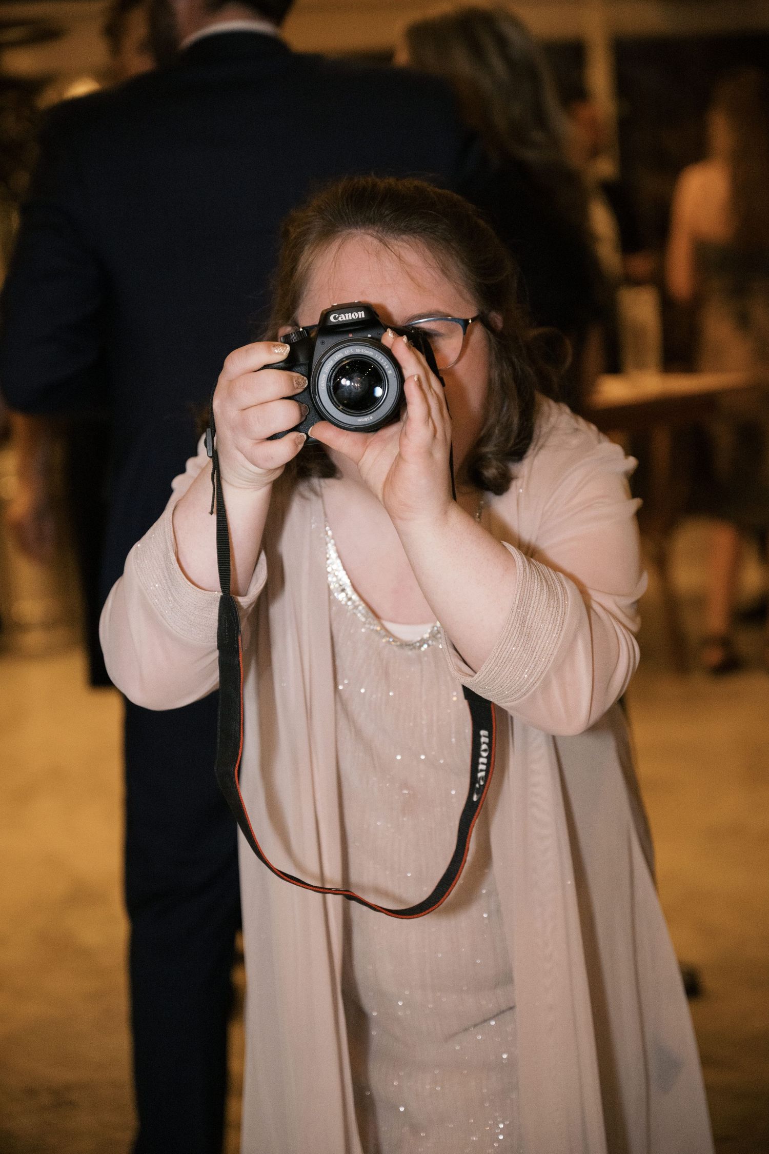 Guest taking photos with a professional camera at an indoor event.