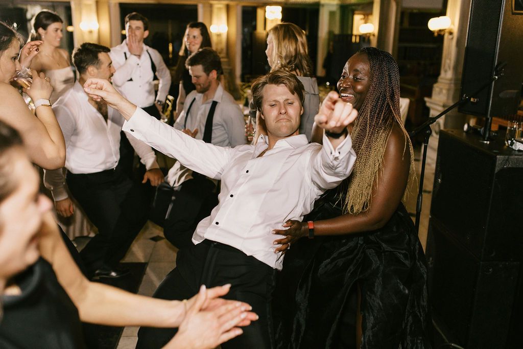 Wedding reception dance floor filled with celebrating guests under warm lighting at George Peabody Library Wedding in Baltimore