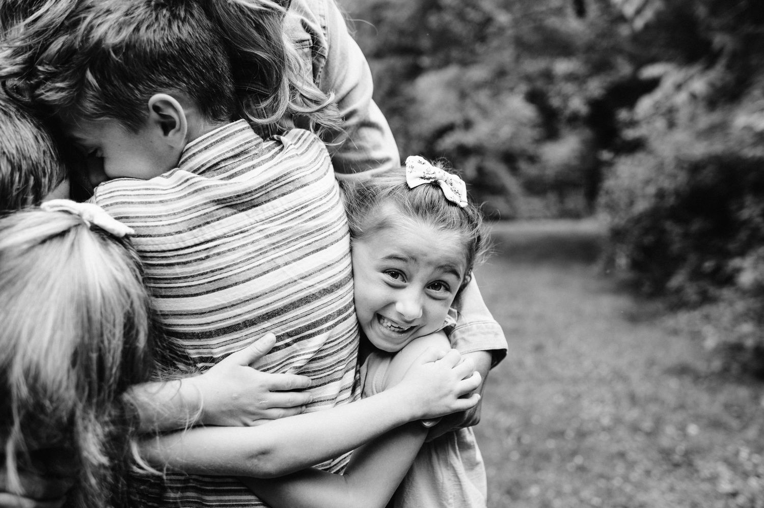 Black and white candid moment of joyful embrace outdoors.