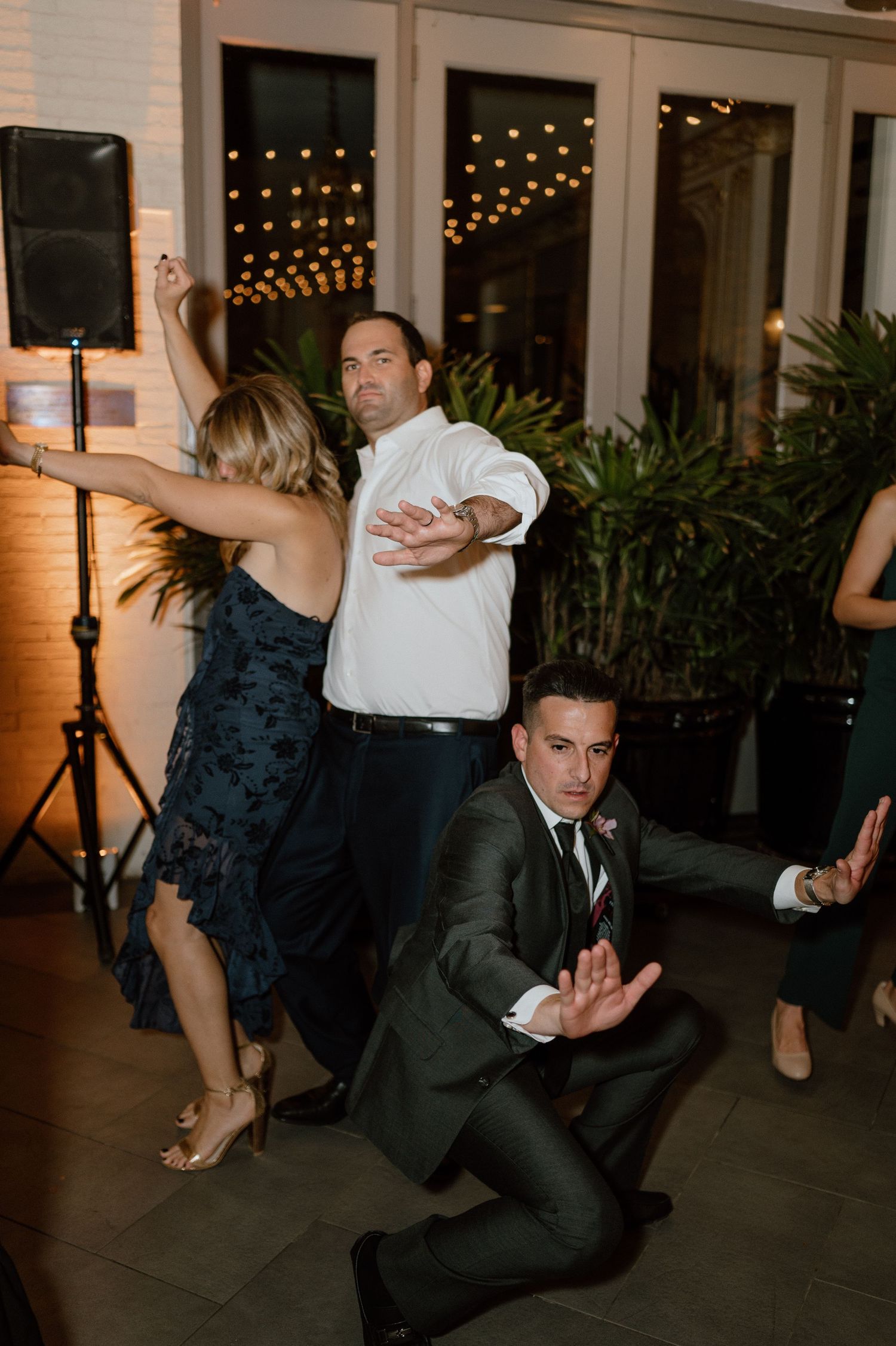 Wedding guests showing off their dance moves at a lively reception party.