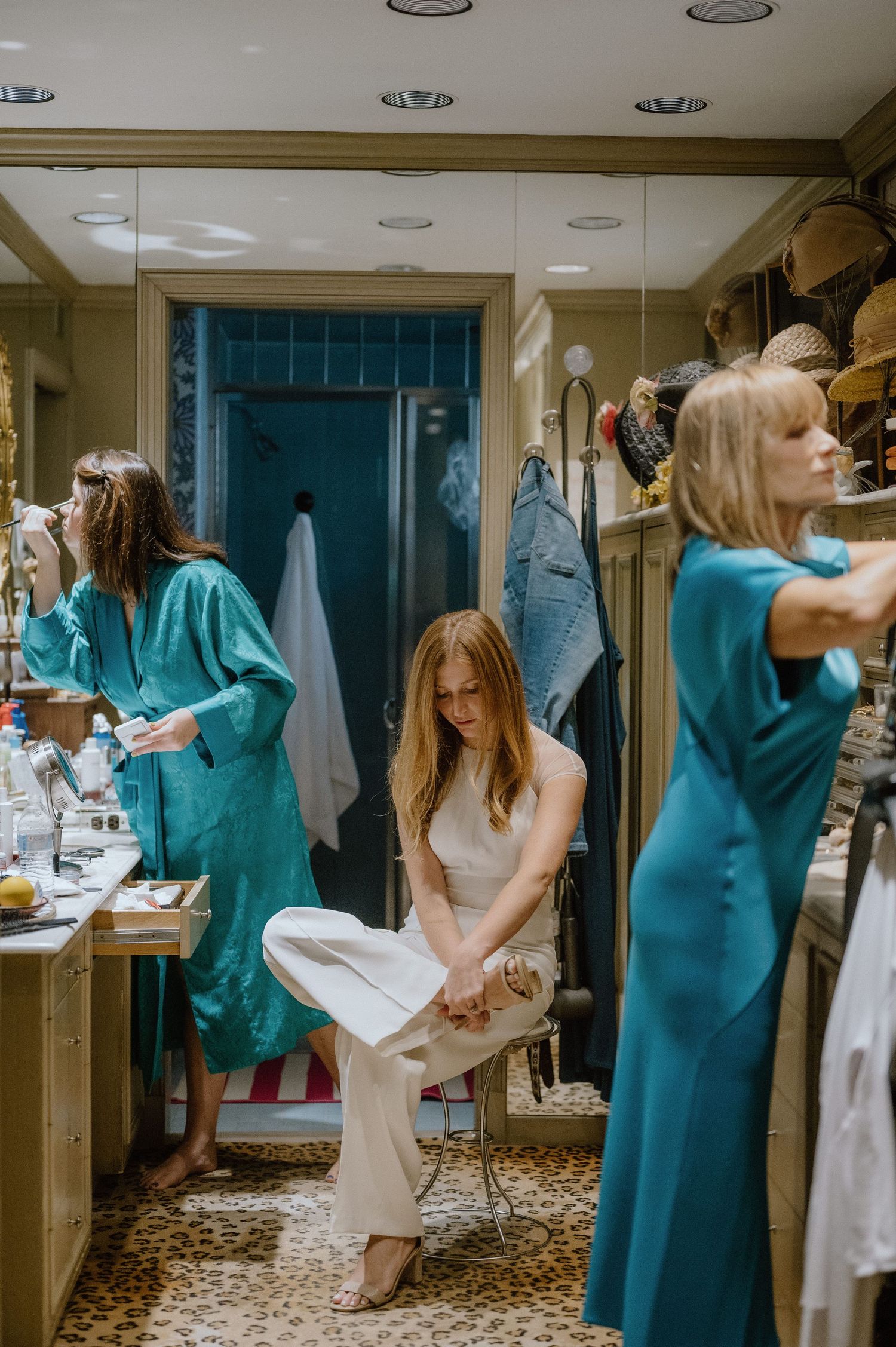 Preparation scene in a dressing room with turquoise robes and white attire.
