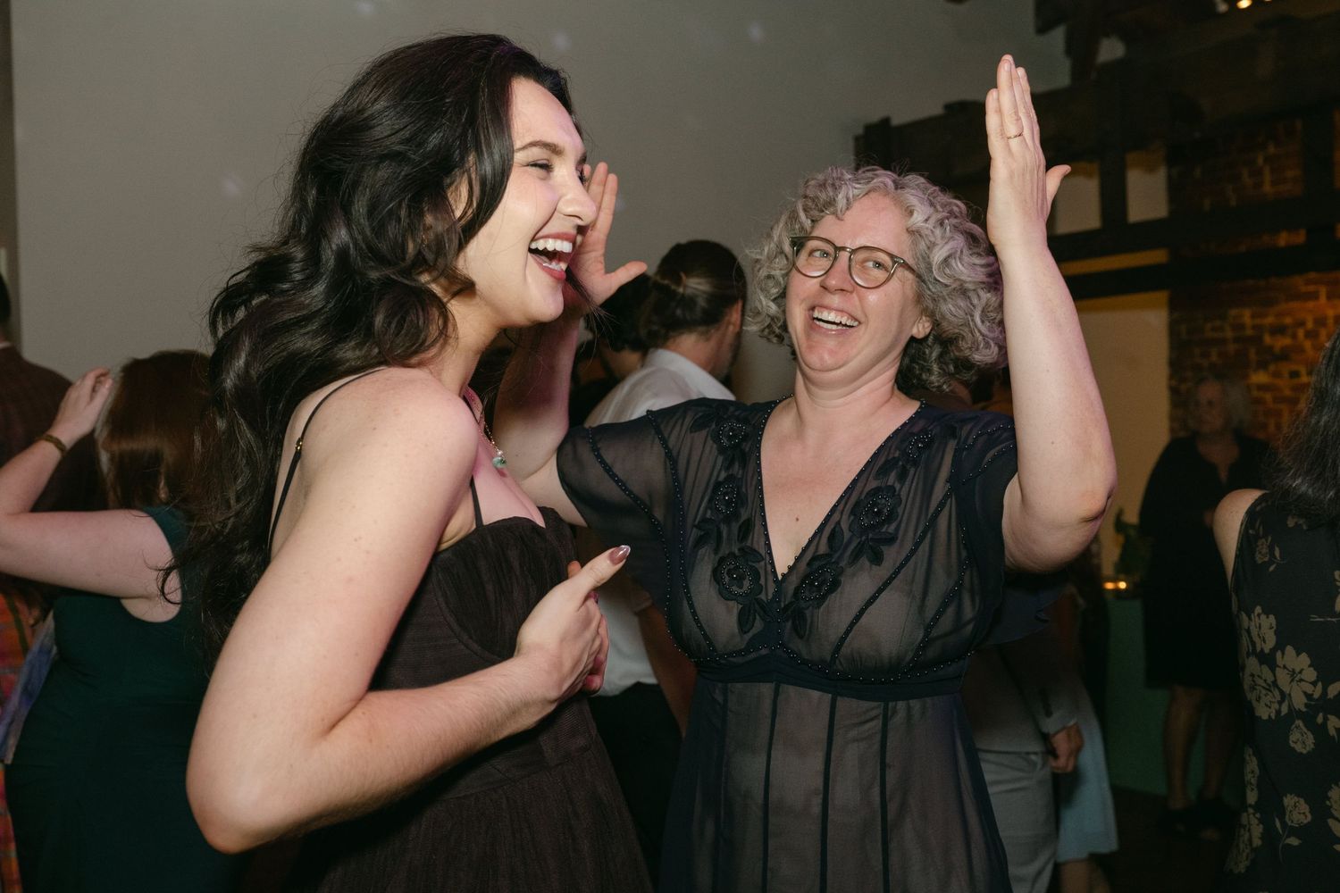 Lively party scene with guests dancing and celebrating under indoor lighting.