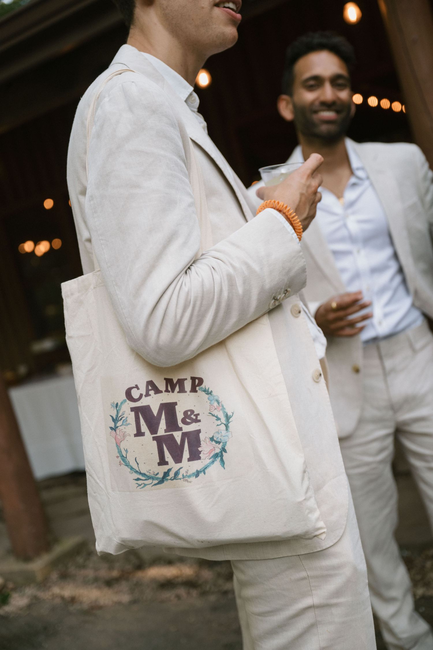 Close-up of a canvas tote bag with Camp M&M logo at an outdoor event.