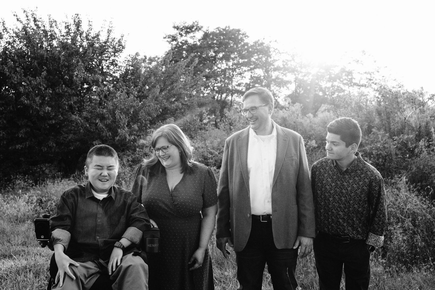 Black and white portrait of family group standing together outdoors.