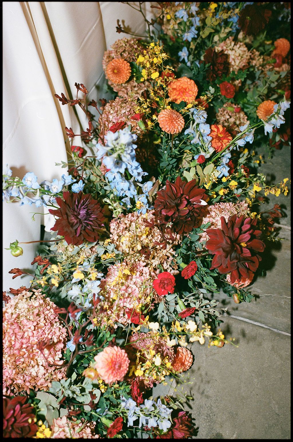 Vibrant floral arrangement featuring coral dahlias, yellow blooms, and eucalyptus greenery at Strong Mansion on Sugarloaf Mountain on film