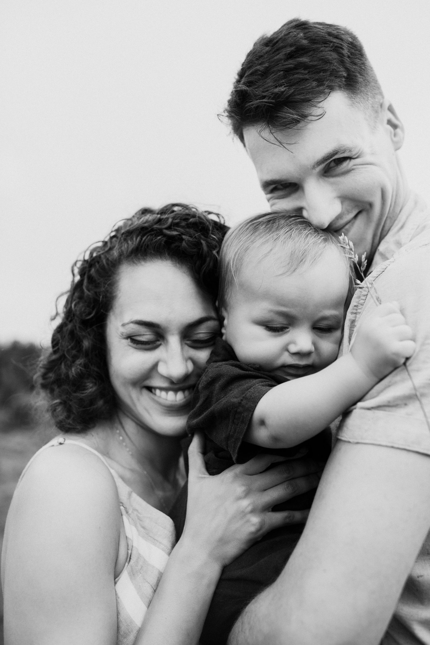 Black and white portrait of family sharing intimate moment together.