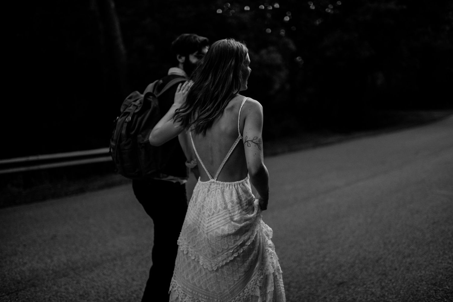 Black and white photo of a romantic moment on a dark road.