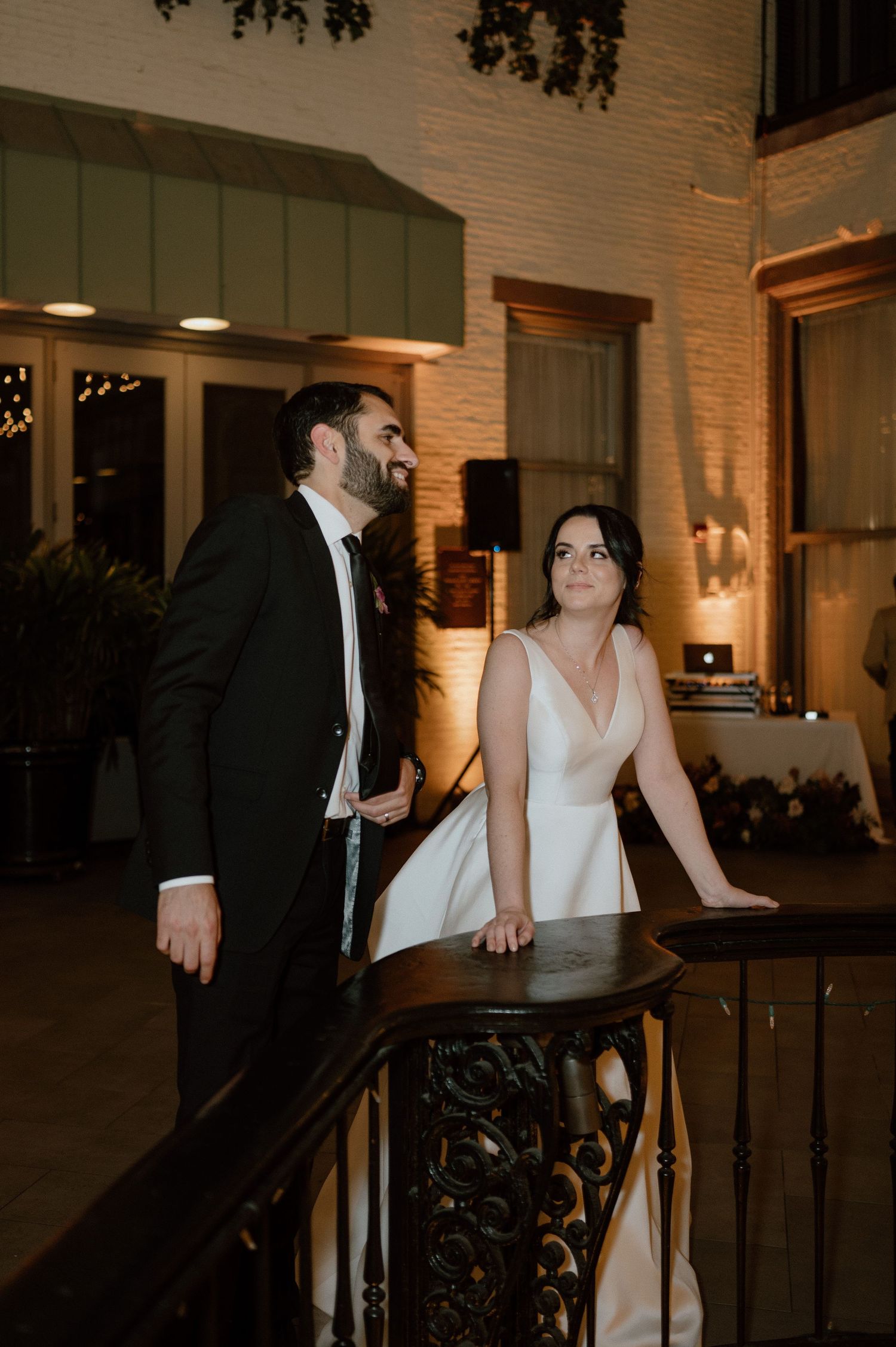 Candlelit indoor venue with ornate railing and architectural details.