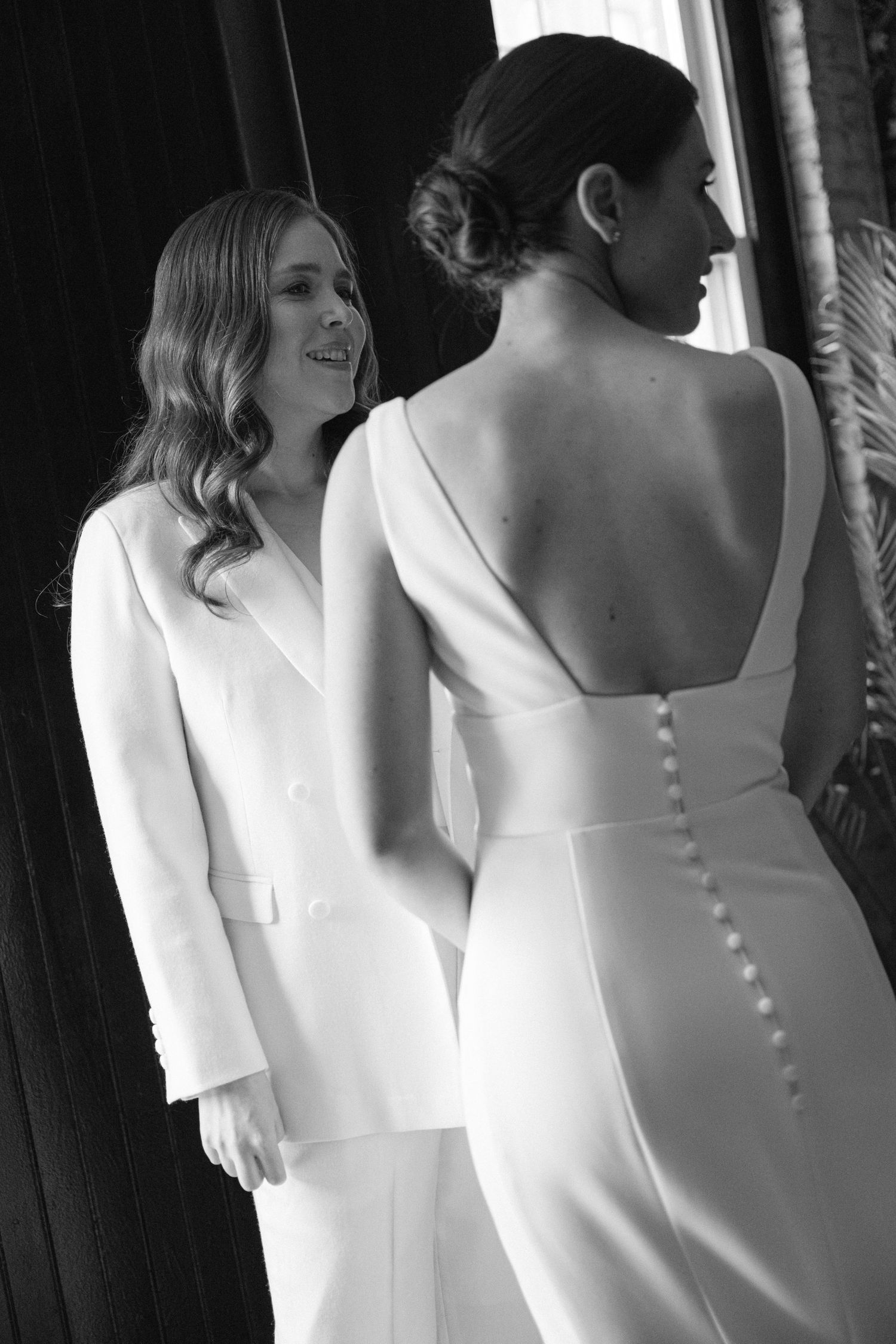 An elegant white wedding ensemble with a buttoned back detail shown in black and white.