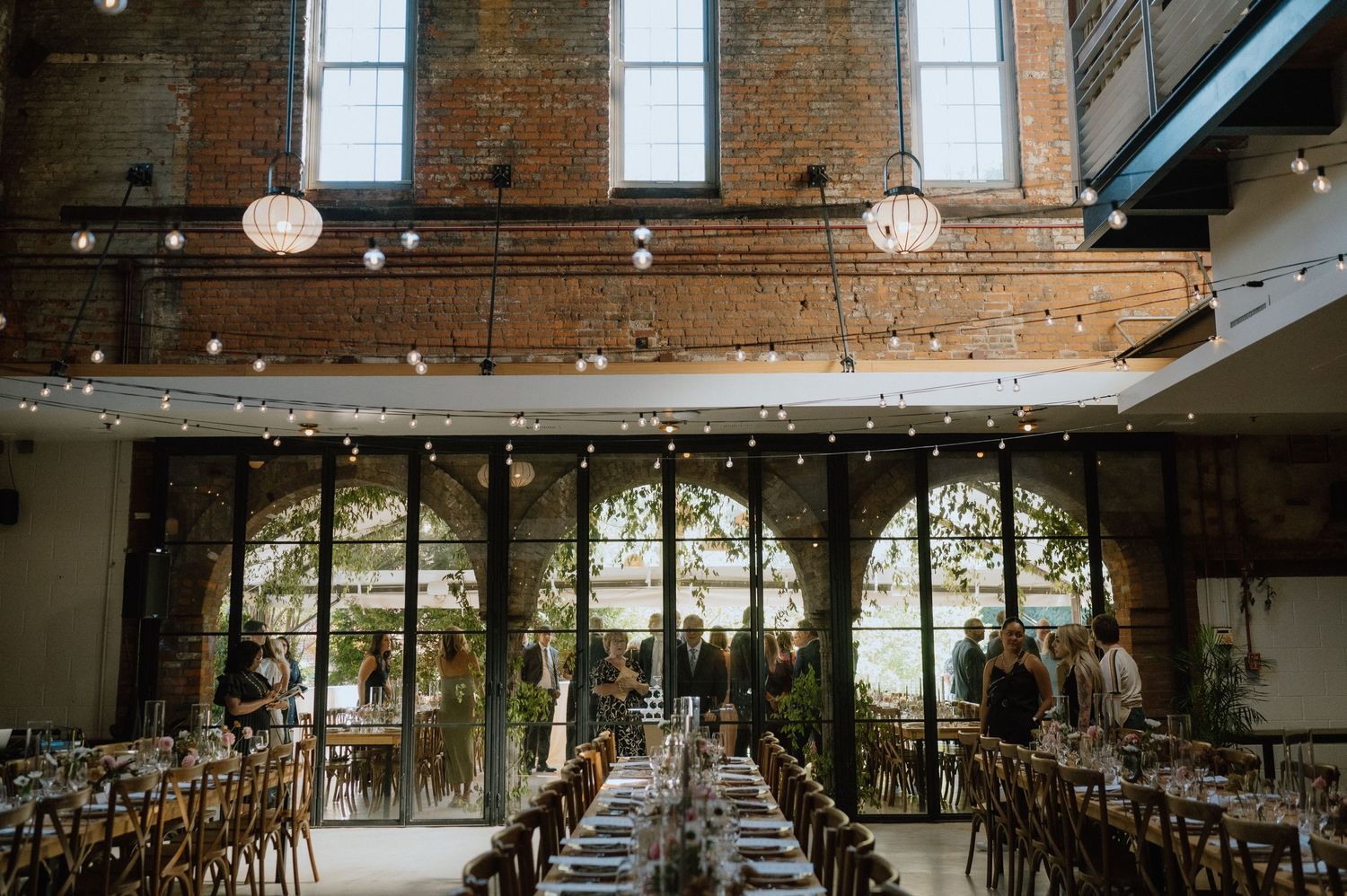 Rustic wedding reception venue with exposed brick walls and string lights.