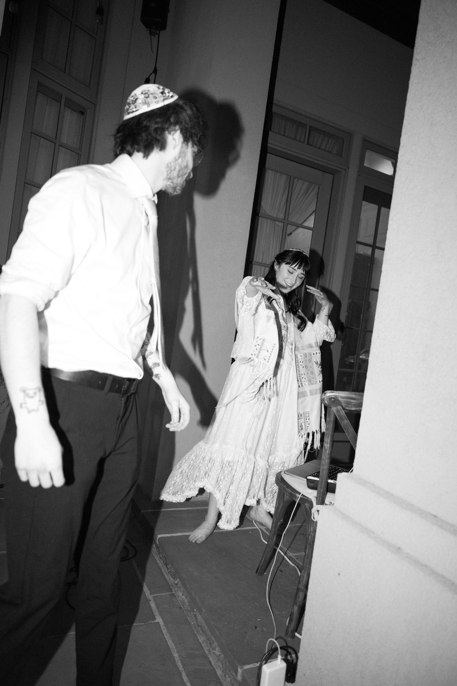 People walking through a hallway in formal attire captured in black and white.