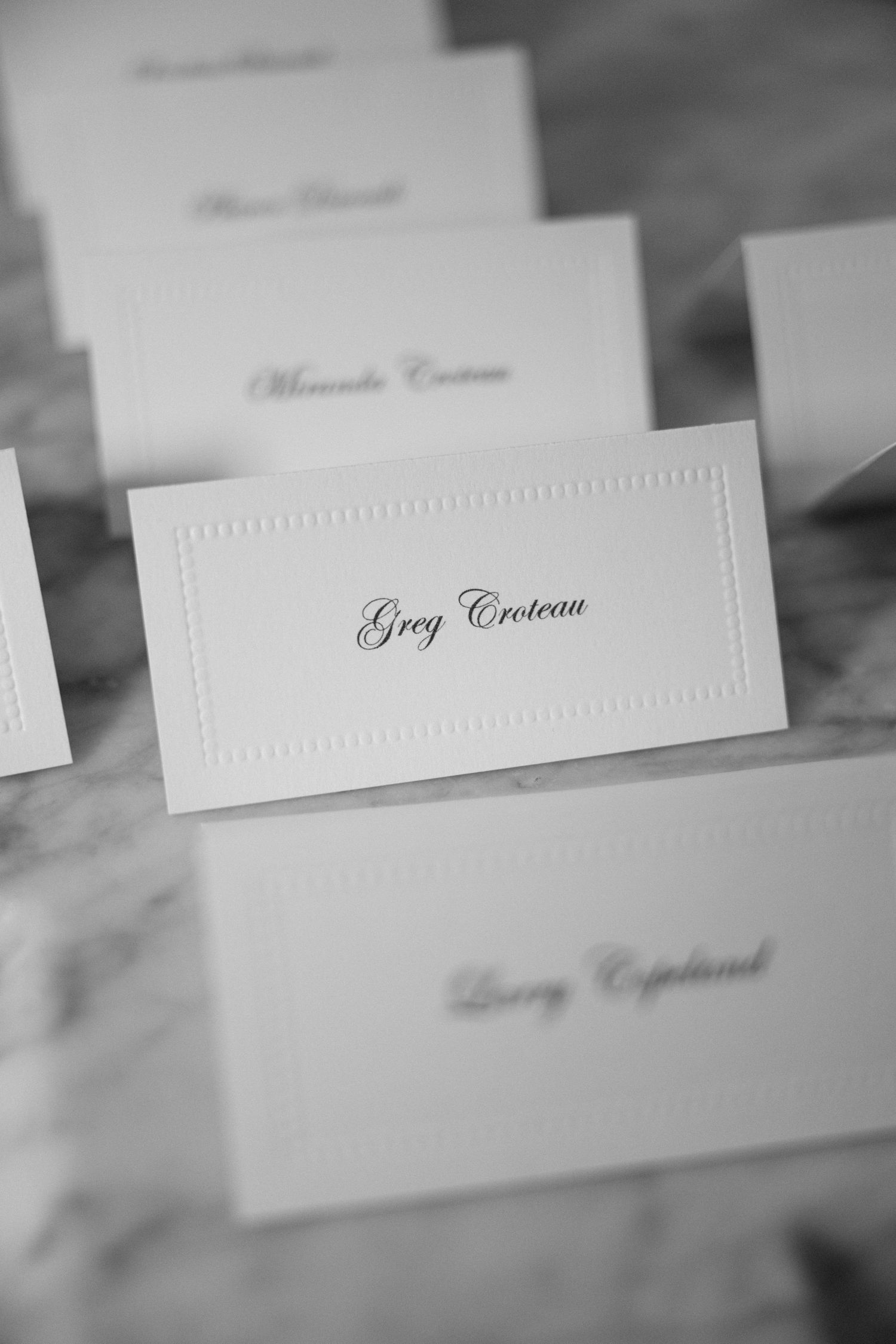 Elegant embossed place card with calligraphy writing displayed at formal event.