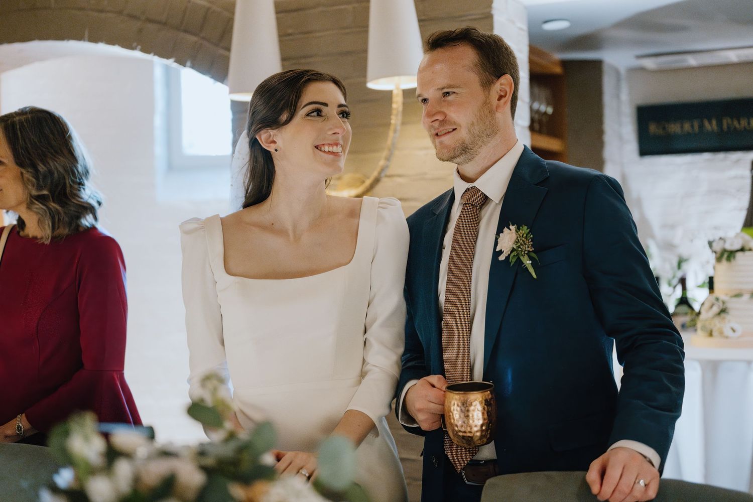 An intimate wedding reception moment with elegant decor and warm lighting at an indoor venue.