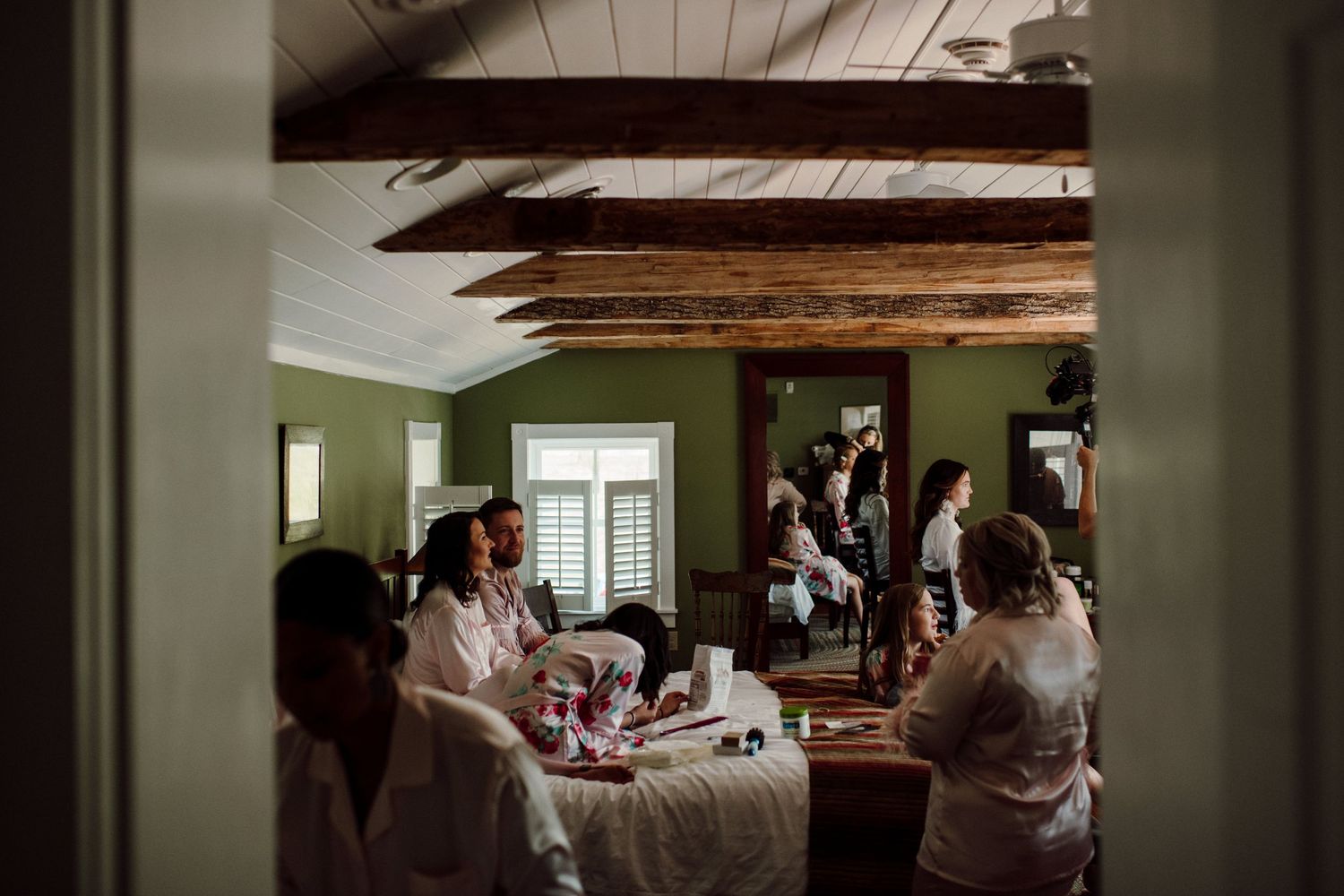 Interior room with rustic wooden beams where wedding party preparations are taking place.